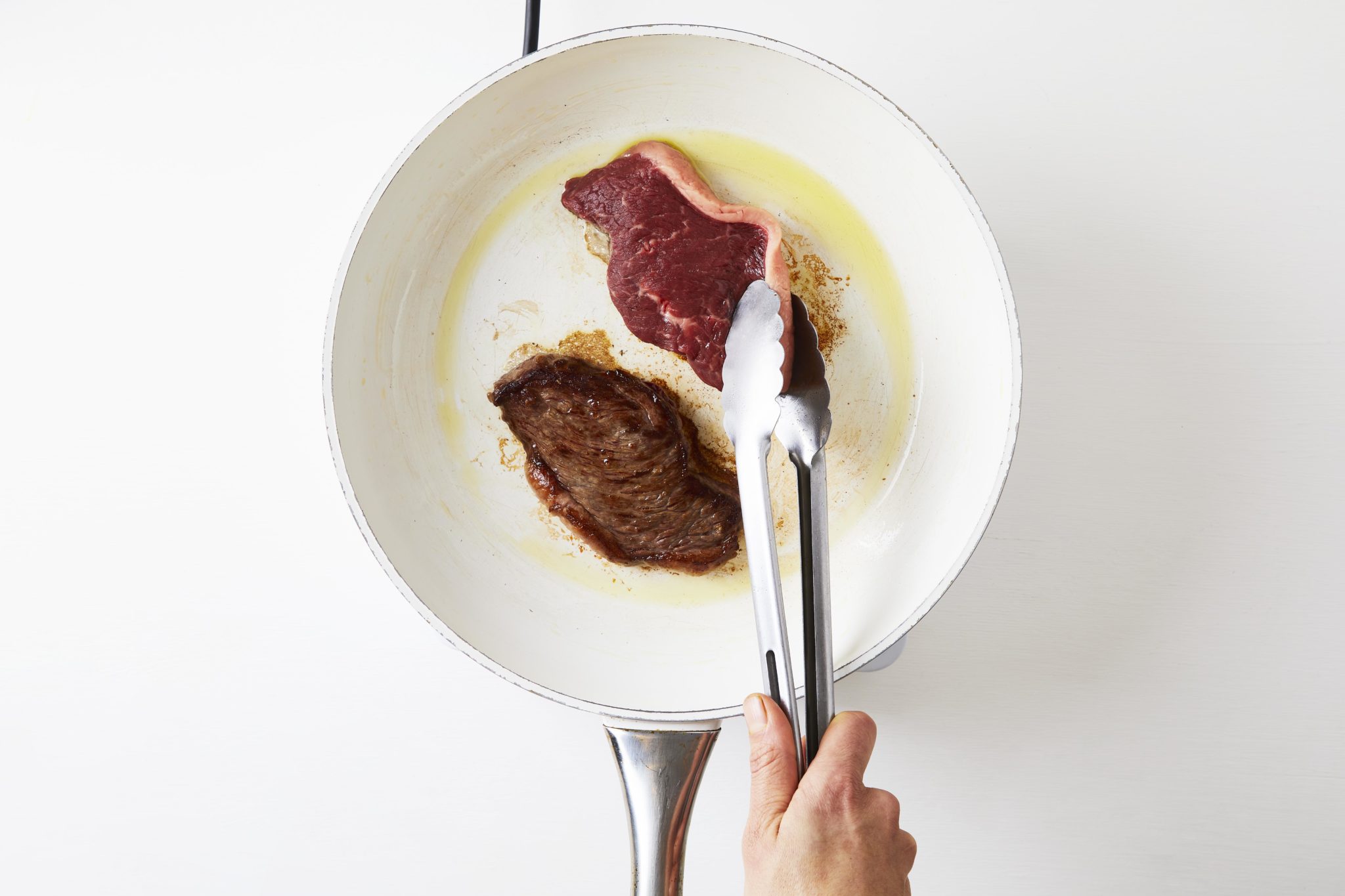 frying steak in a pan