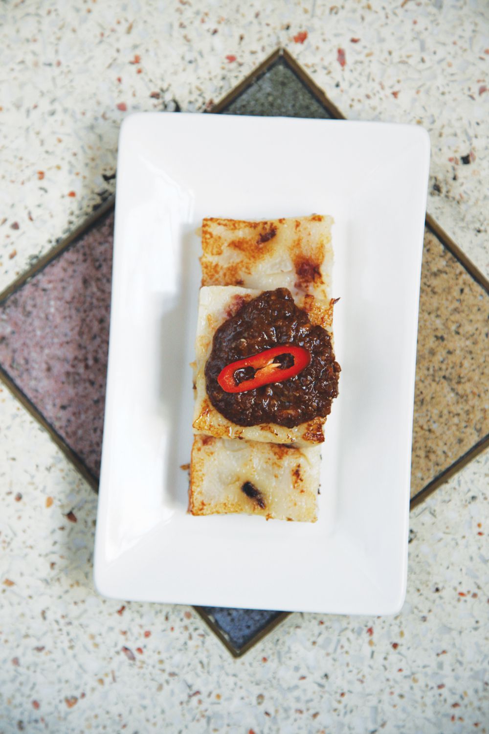 A Chinese New Year treat, these daikon and rice flour cakes are flavored with savory dried sausage and served with a spicy hoisin sauce. <a href="https://www.saveur.com/article/Recipes/Luo-Go-Bao/">Get the recipe for Daikon Cake with Garlic Hoisin Sauce (Luo Go Bao)</a>