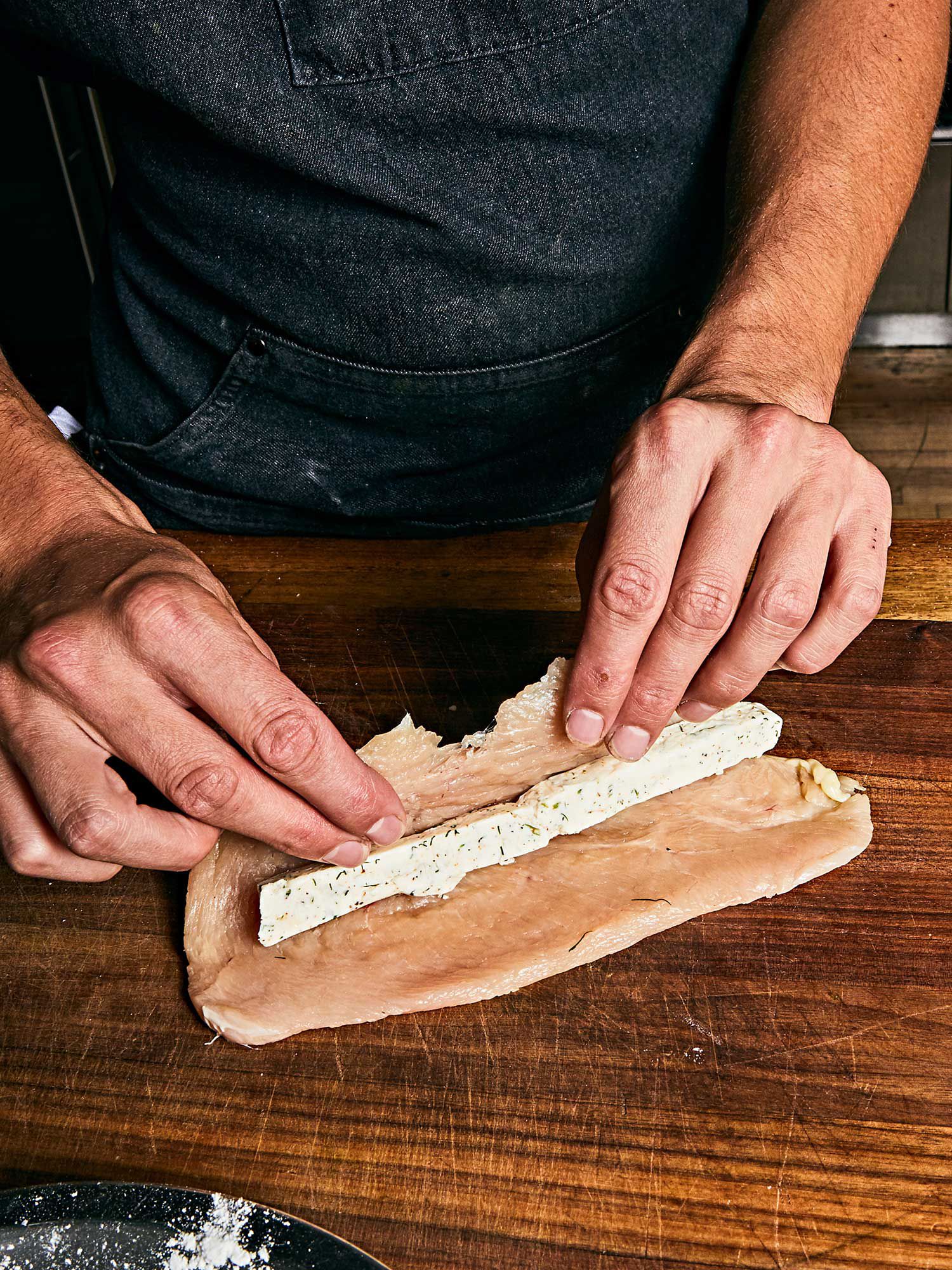 A thin log of compound butter is rolled up inside the chicken cutlet.