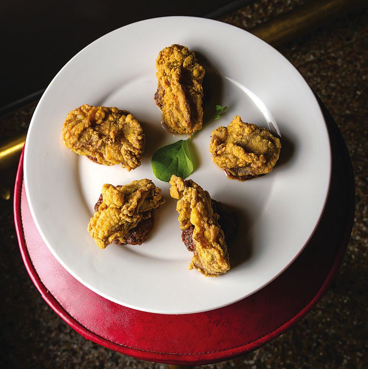 Fried oysters are paired with a garlicky sauce in a toothsome appetizer served at Upperline, a restaurant in New Orleans' Uptown neighborhood. <a href="https://www.saveur.com/article/Recipes/Upperlines-Oysters-St-Claude/">Get the recipe for Upperline's Oysters St. Claude</a>