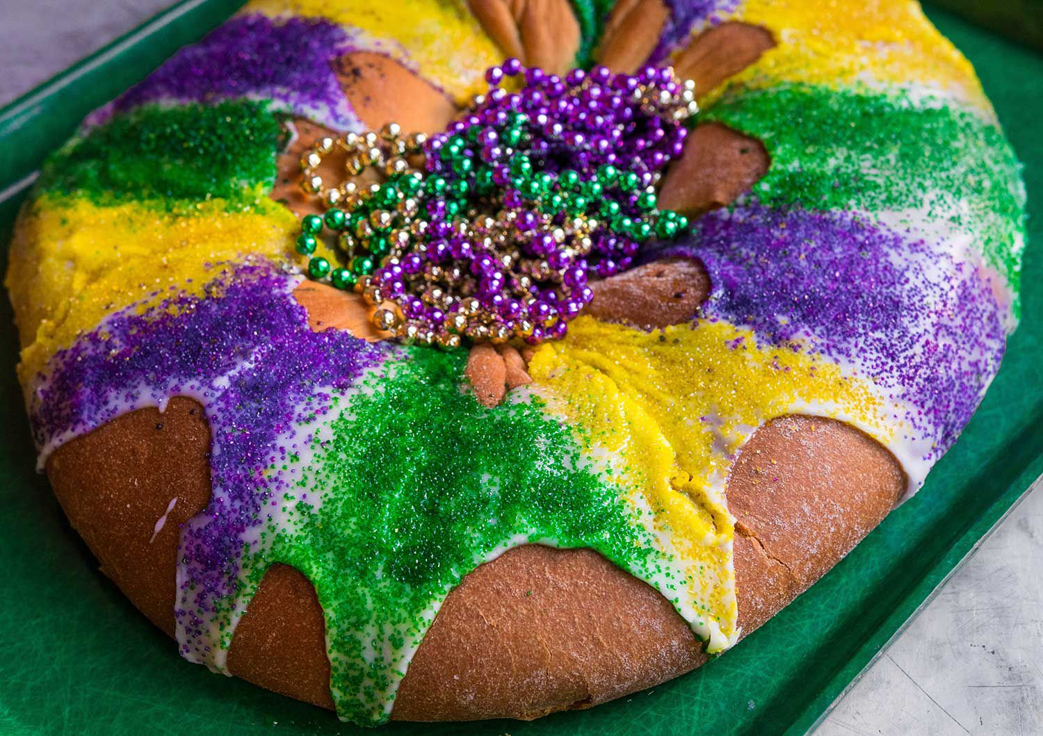 This traditional Mardi Gras cake, made here with rich brioche dough and stuffed with a decadent cream cheese filling, is drizzled with a buttermilk glaze and sprinkled with crunchy green, gold, and purple sanding sugars. <a href="https://www.saveur.com/article/Recipes/King-Cake/">Get the recipe for King Cake</a>
