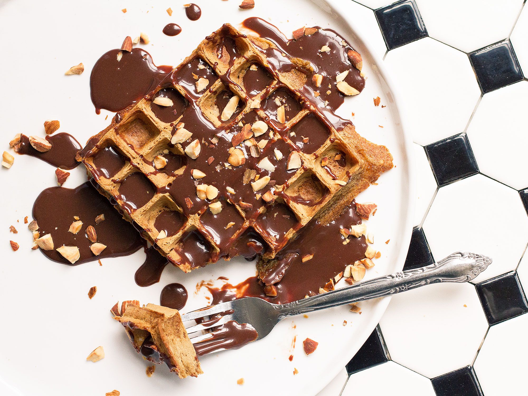 Almond flour and espresso powder give bittersweet edge to these waffles, which are glossed with a decadent sauce of condensed milk, coffee, and dark chocolate.<a href="https://www.saveur.com/espresso-waffles-with-mocha-sauce-recipe">Get the recipe for Espresso Waffles with Mocha Drizzle</a>