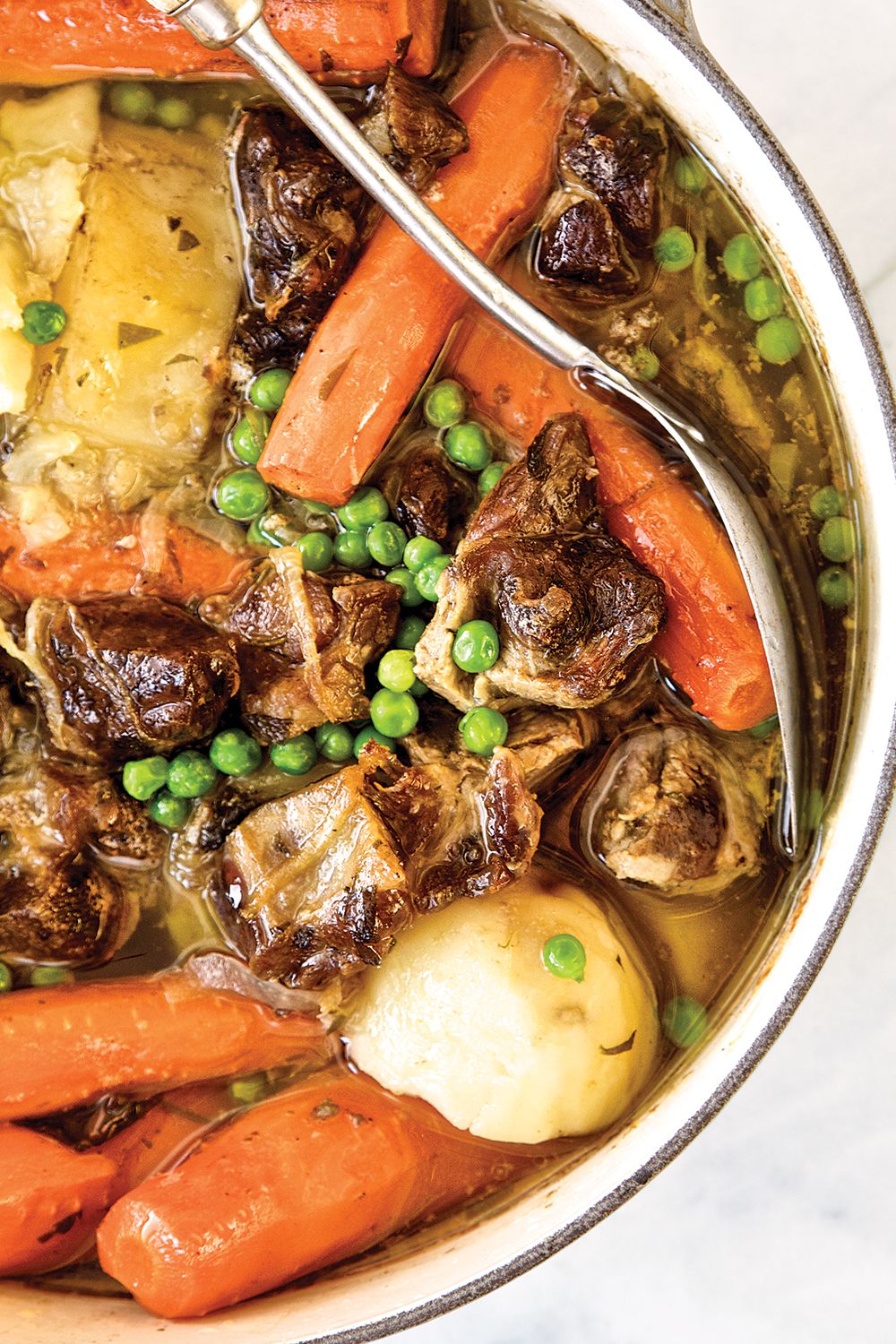 In this traditional warming stew from the Emerald Isle, lamb shoulder is rendered spoon-tender by a simmer and then a long, slow bake with plenty of filling potatoes and aromatic carrots and onions. For bright color and a bit of verdant sweetness, green peas are tossed in toward the end of the cooking. <a href="https://www.saveur.com/article/Recipes/Irish-Stew-">Get the recipe for Irish Stew</a>