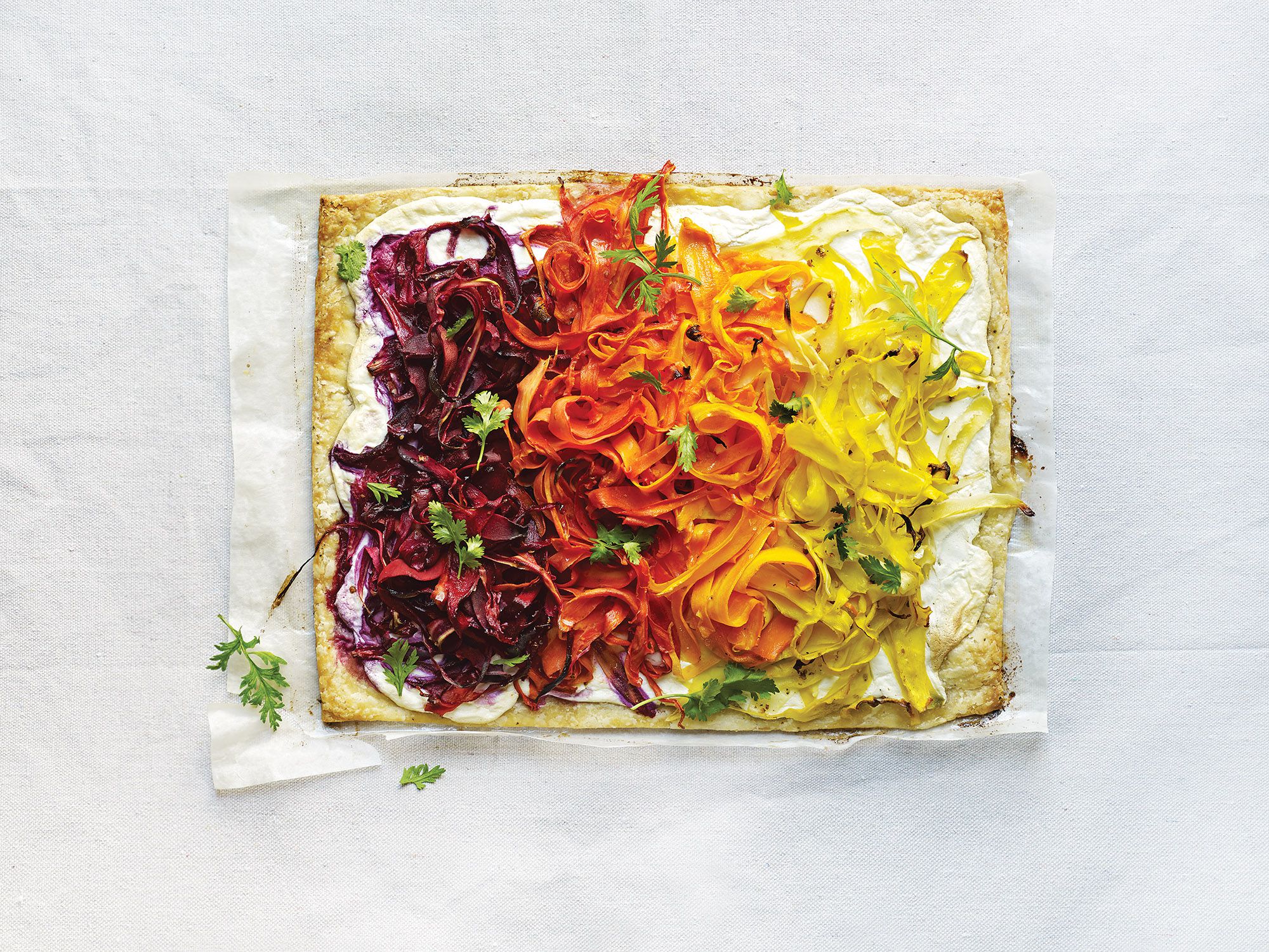 Piles of colorful carrot ribbons—which skew more savory than sweet, thanks to a lemony coriander-flecked dressing—come out of the oven glistening and retaining some of their bite. The keys to the couldn't-be-flakier crust beneath: keeping the ingredients as cold as possible, and not overhandling the dough. Leftovers of the tart can be refrigerated and recrisped in the oven the next day. Get the recipe for <a href="http://www.saveur.com/shaved-carrot-tart-with-ricotta">Shaved Carrot Tart with Ricotta</a>