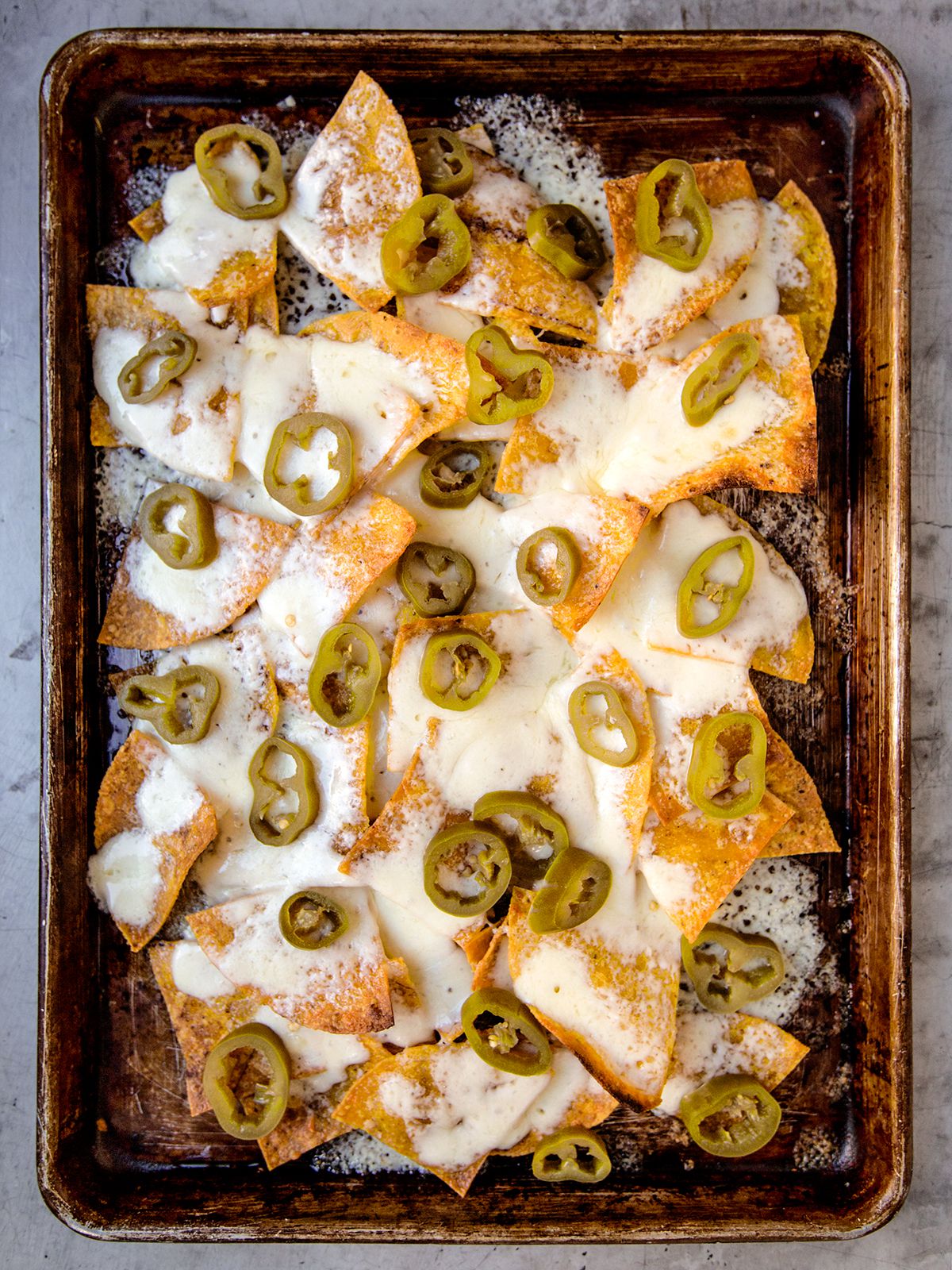 In the 1950s, pickled jalapeños were sold whole or in strips; the now-familiar rings became available, not coincidentally, after nachos gained national popularity. Today, supermarkets offer an array of tortilla chips, shredded cheeses, and salsas, all intended to ease preparation of this Tex-Mex classic. This recipe brings us back to the joys of a simpler nacho. Get the recipe for <a href="https://www.saveur.com/article/Recipes/Nachos">Nachos</a>