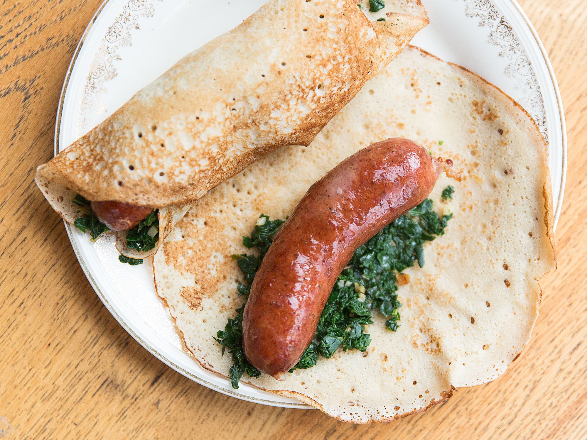 Amy Thielen's interpretation of breakfast for dinner: these delicately sweet and savory pancakes, given lift by yeast and flavored with some bacon fat. They're perfect for rolling up around crisp sausages, but are good filled pretty much everything. Get the recipe for <a href="https://www.saveur.com/supper-pancakes-sausage-greens-recipe">Supper Pancakes With Smoked Sausage</a>