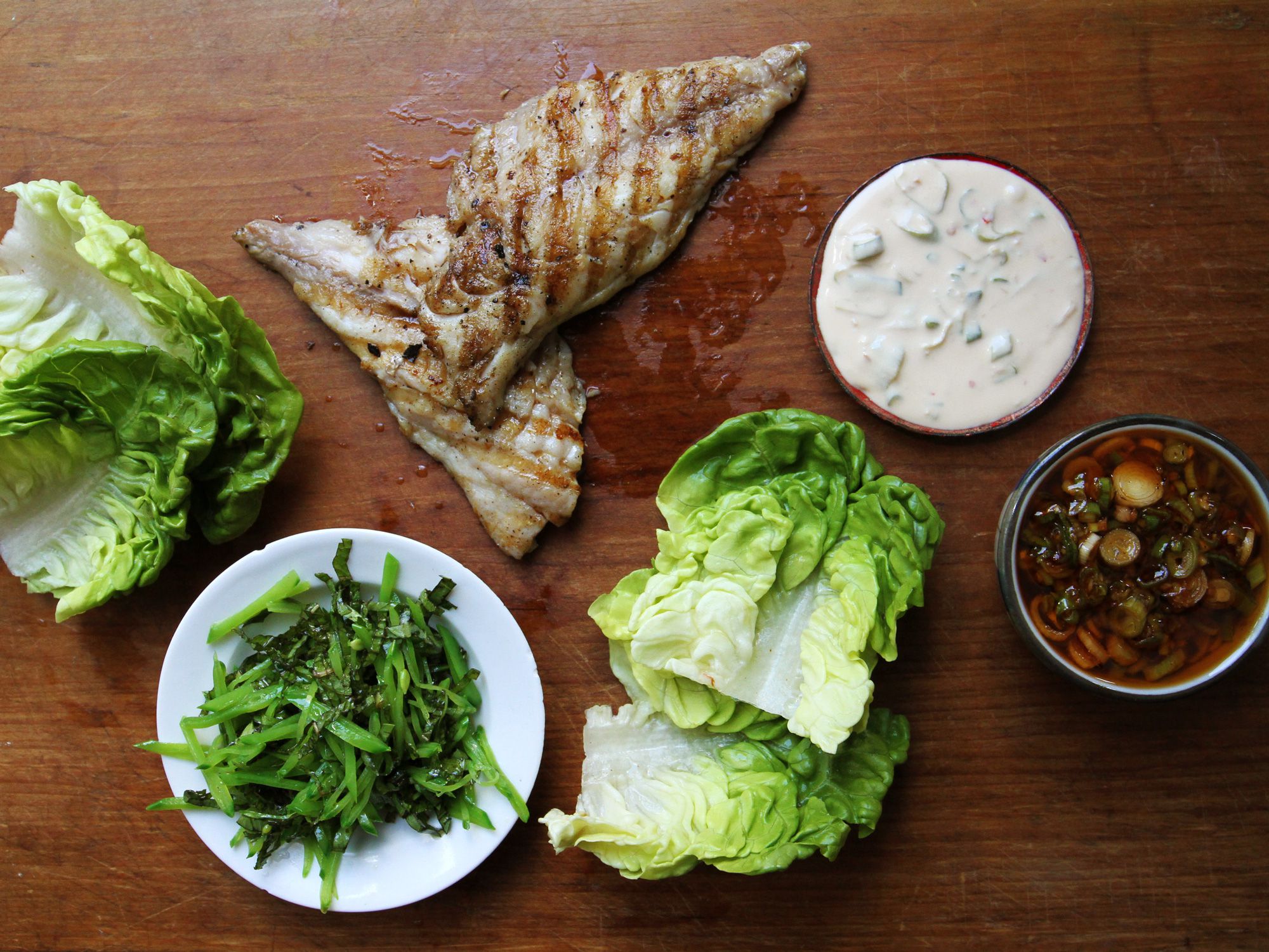 <em>Ssäm</em>, which is Korean for "wrapped," refers to the lettuce wraps that enclose spicy grilled fish in this recipe from Matthew Rudofker, executive chef at New York City's Momofuku Ssäm Bar. Get the recipe for <a href="https://www.saveur.com/fish-ssam-spicy-chile-sauce/">Fish Ssäm with Spicy Chile Sauce</a>