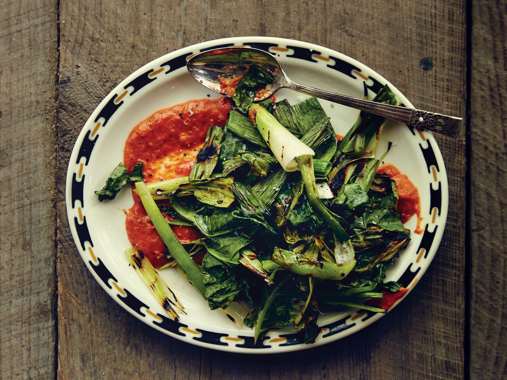 When buying leeks for this dish, cookbook author Amy Thielen says to look for ones that have all or most of their dark green tops still attached. If trimmed leeks are all you can find, use the dark and light green parts only. Get the recipe for <a href="https://www.saveur.com/grilled-greens-and-leek-tops-chile-garlic-sauce-recipe/">Grilled Greens and Leek Tops with Chile-Garlic Sauce</a>