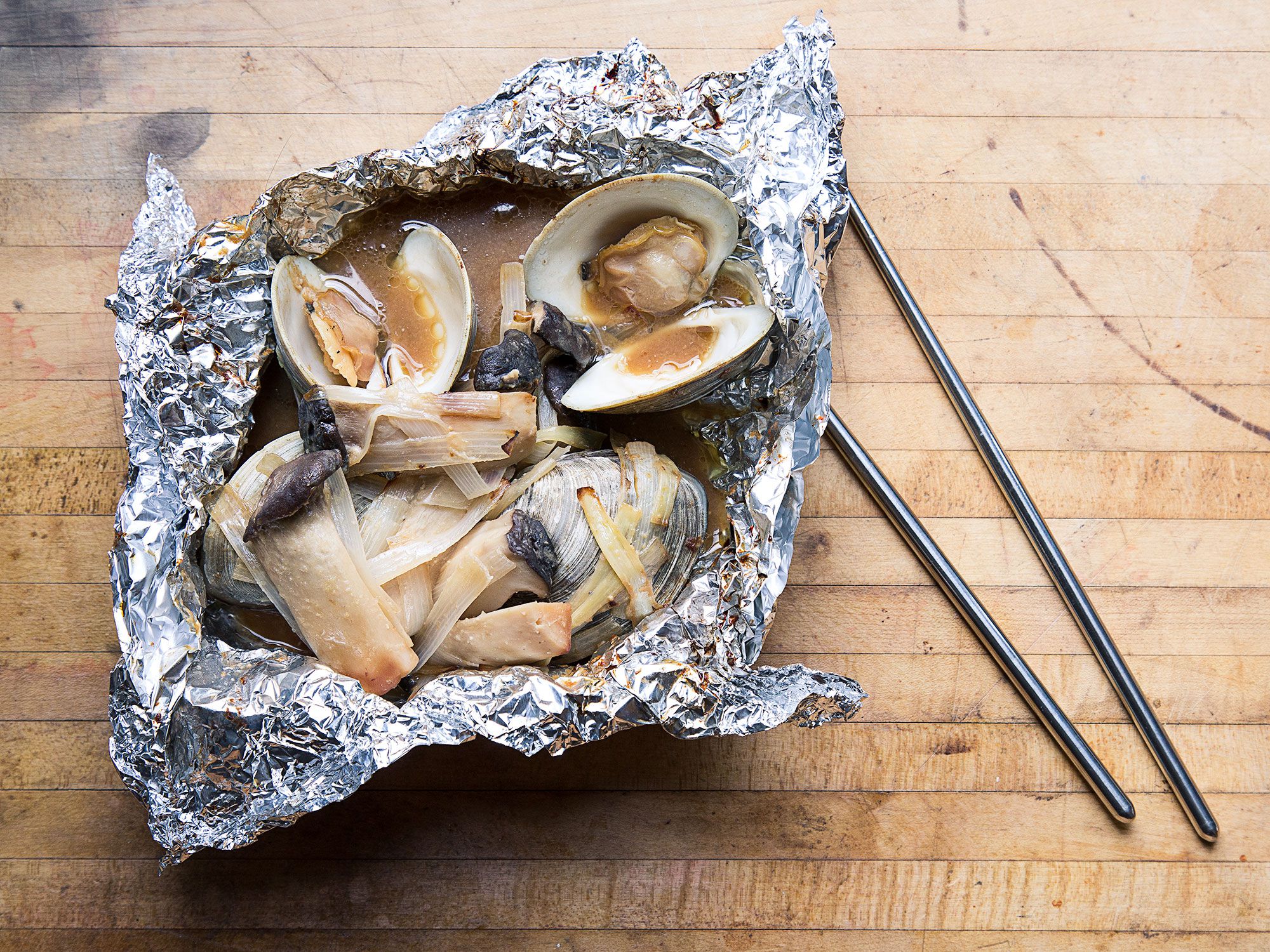 Clams, leeks, and king oyster mushrooms get cooked in a foil pouch that resembles a Jiffy Pop. Get the recipe for <a href="http://www.saveur.com/clam-leek-mushroom-foil-yaki-recipe">Clam, Leek, and King Oyster Mushroom Foil Yaki</a>