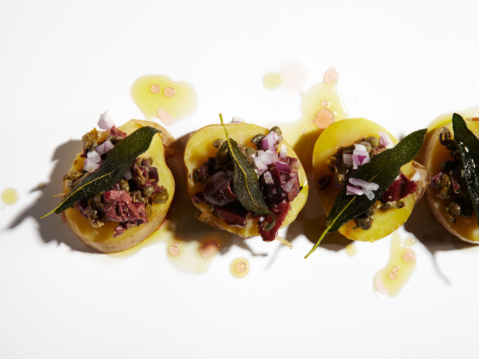 This flavor-packed hors d'oeuvres from Francis Mallmann is topped with an umami-rich relish of capers, anchovies, and kalamata olives. Get the recipe for <a href="https://www.saveur.com/mallmann-vinegar-potatoes-with-olive-caper-relish-recipe/">Vinegar-Marinated Potatoes with Olives and Capers</a>