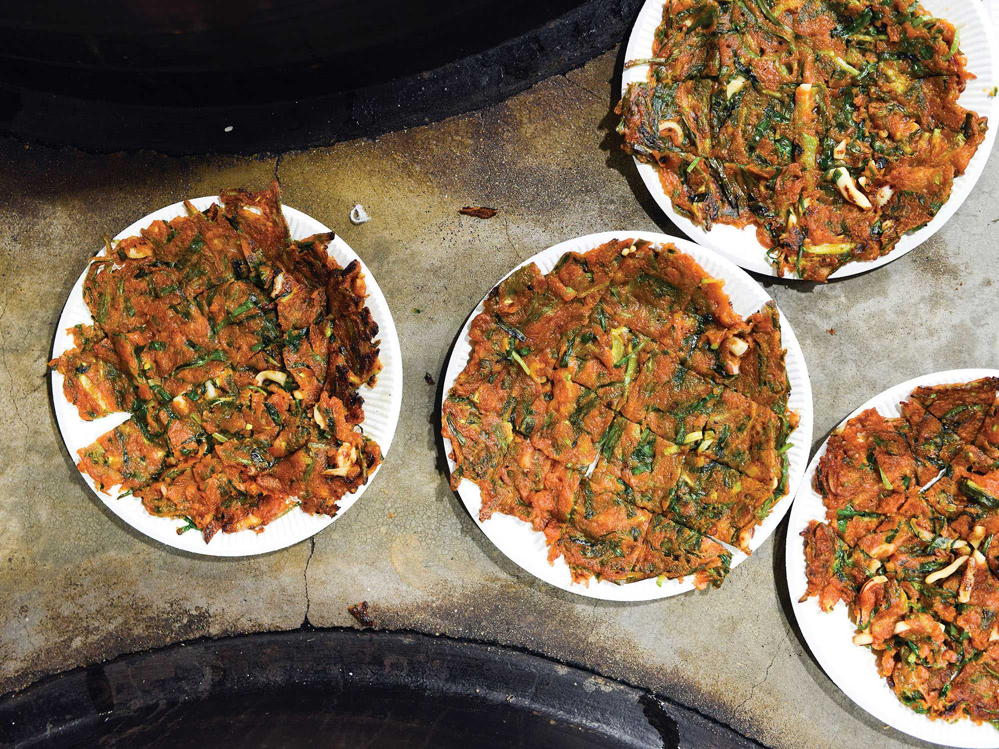 Crispy fried scallion pancakes with scallions, ramps, shrimp and julienned carrots. Pairs well as a snack with makgeolli (Korean rice beer). <a href="https://www.saveur.com/pajeon-korean-scallion-pancakes-recipe/">Get the recipe for Korean Scallion Pancakes (Pajeon) »</a>