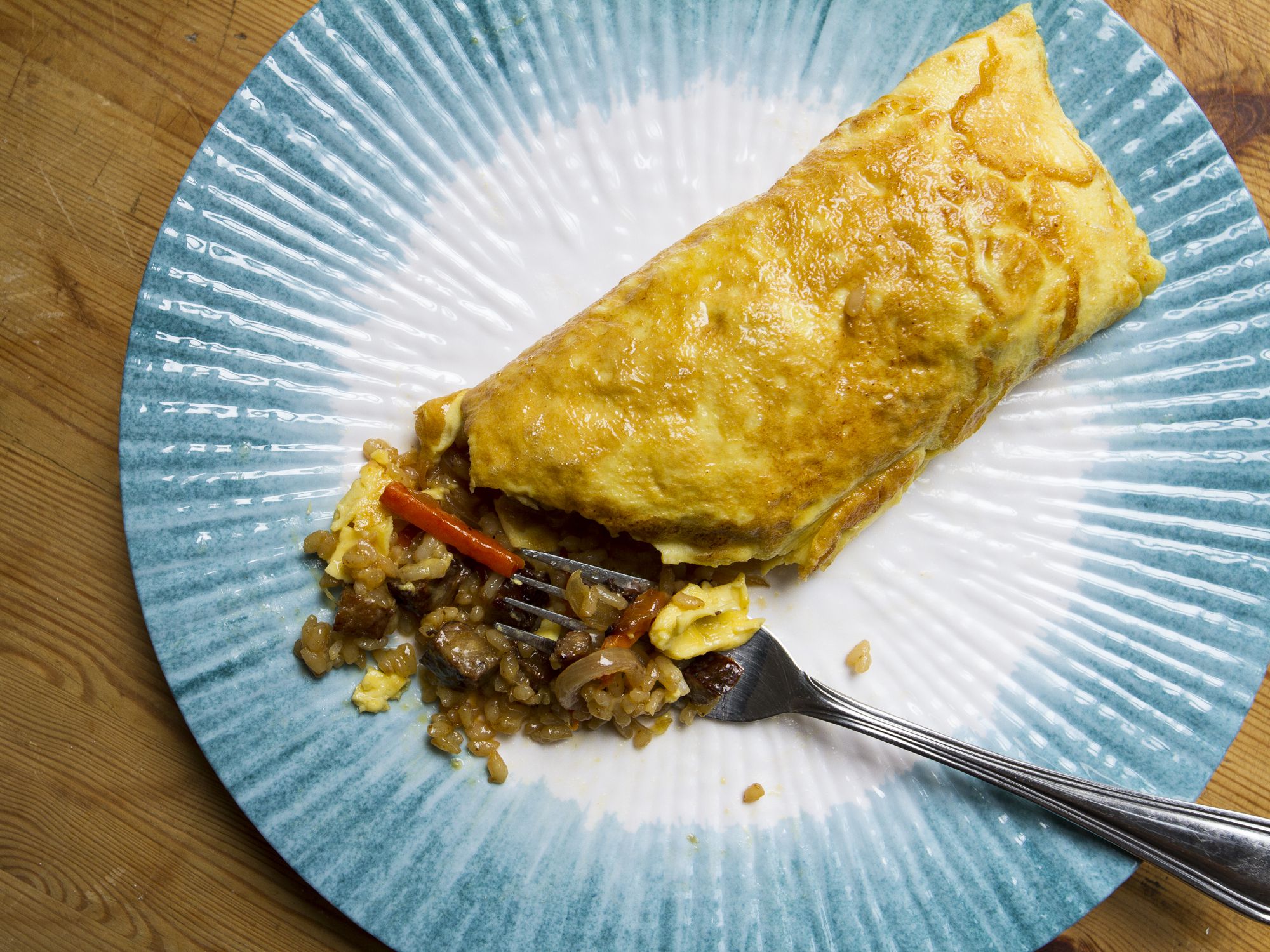 In this dish, a popular order at Teshima's, a restaurant in the Big Island town of Kealakekua, a thin omelette is folded around a filling of fried rice and sausage. <a href="http://www.saveur.com/article/Recipes/Fried-Rice-Omelette">Get the recipe for Fried Rice Omelette »</a>
