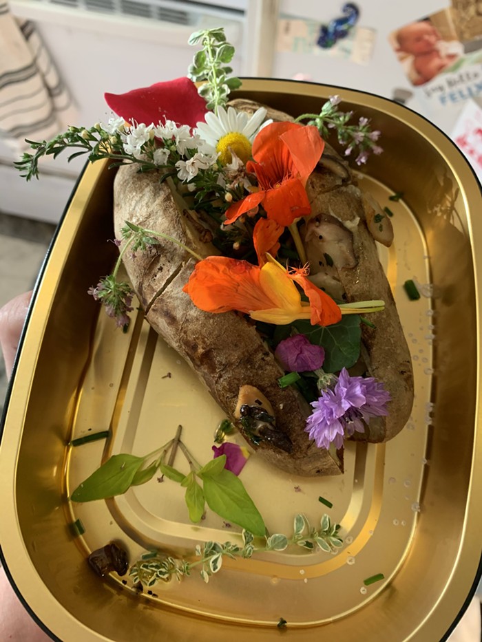 Heres what my baked potato looked like after it was finally warm enough to eat, and after I had garnished it with the chives and flowers provided.