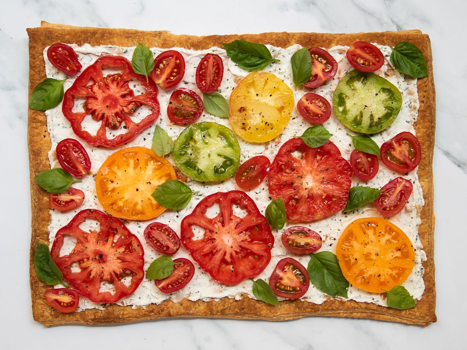 Sliced tomato tart on a marble countertop