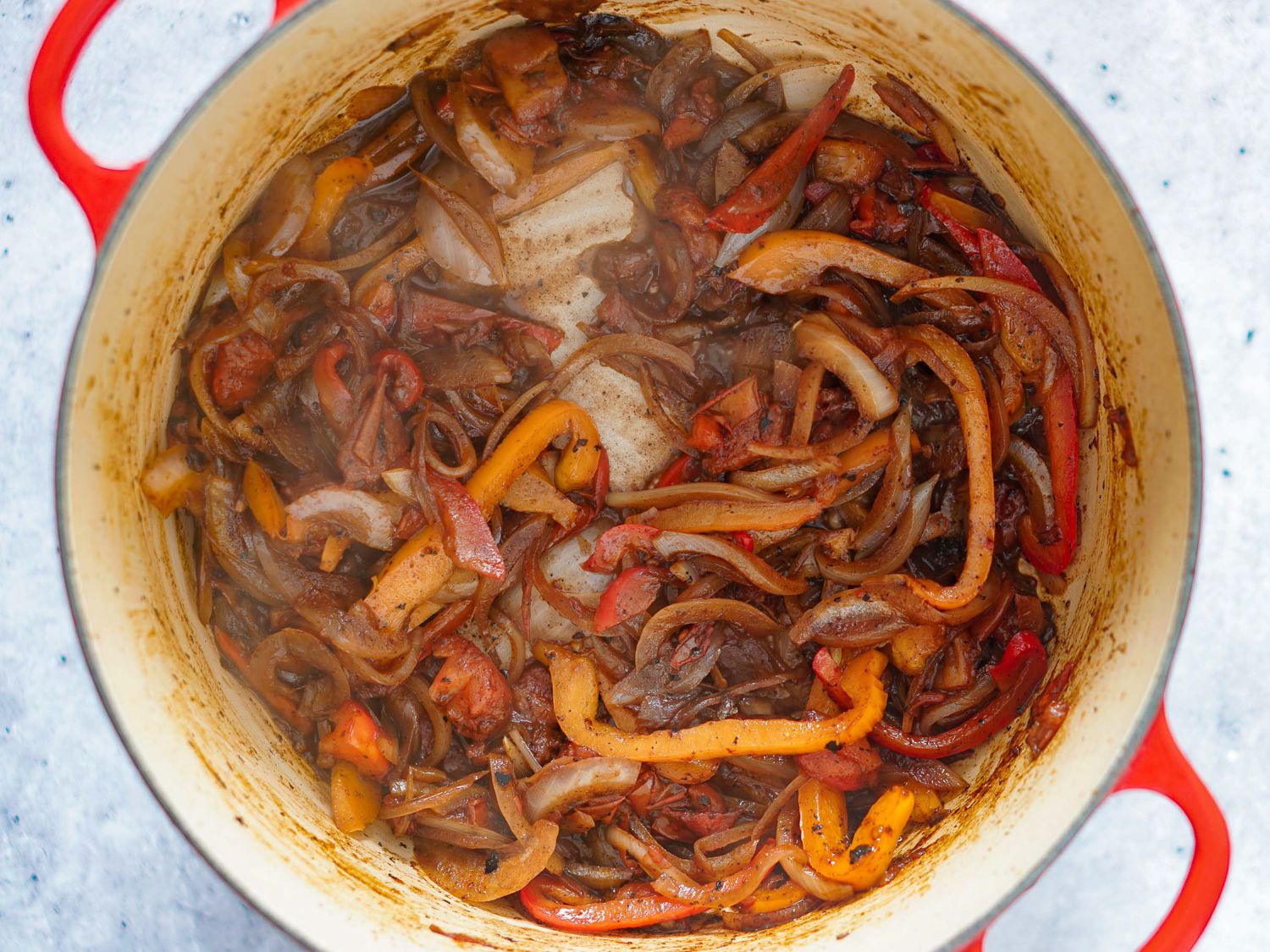 Peppers and onion being sautéd in Dutch oven