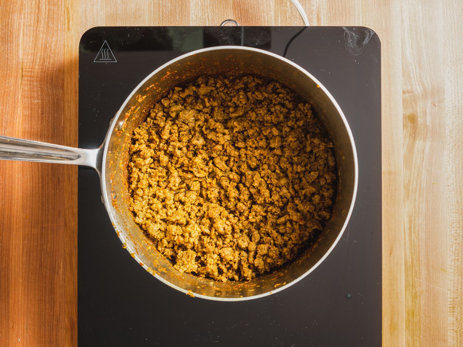 Overhead view of lamb kheema being prepared in a sacuepan