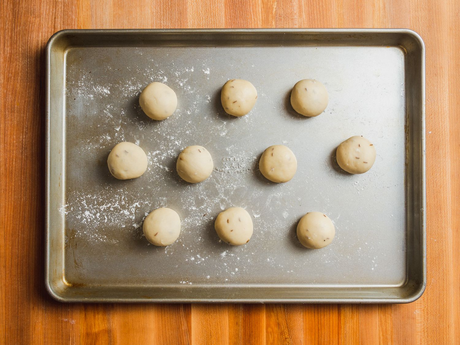 10 samosa pastry dough balls on a floured baking sheet