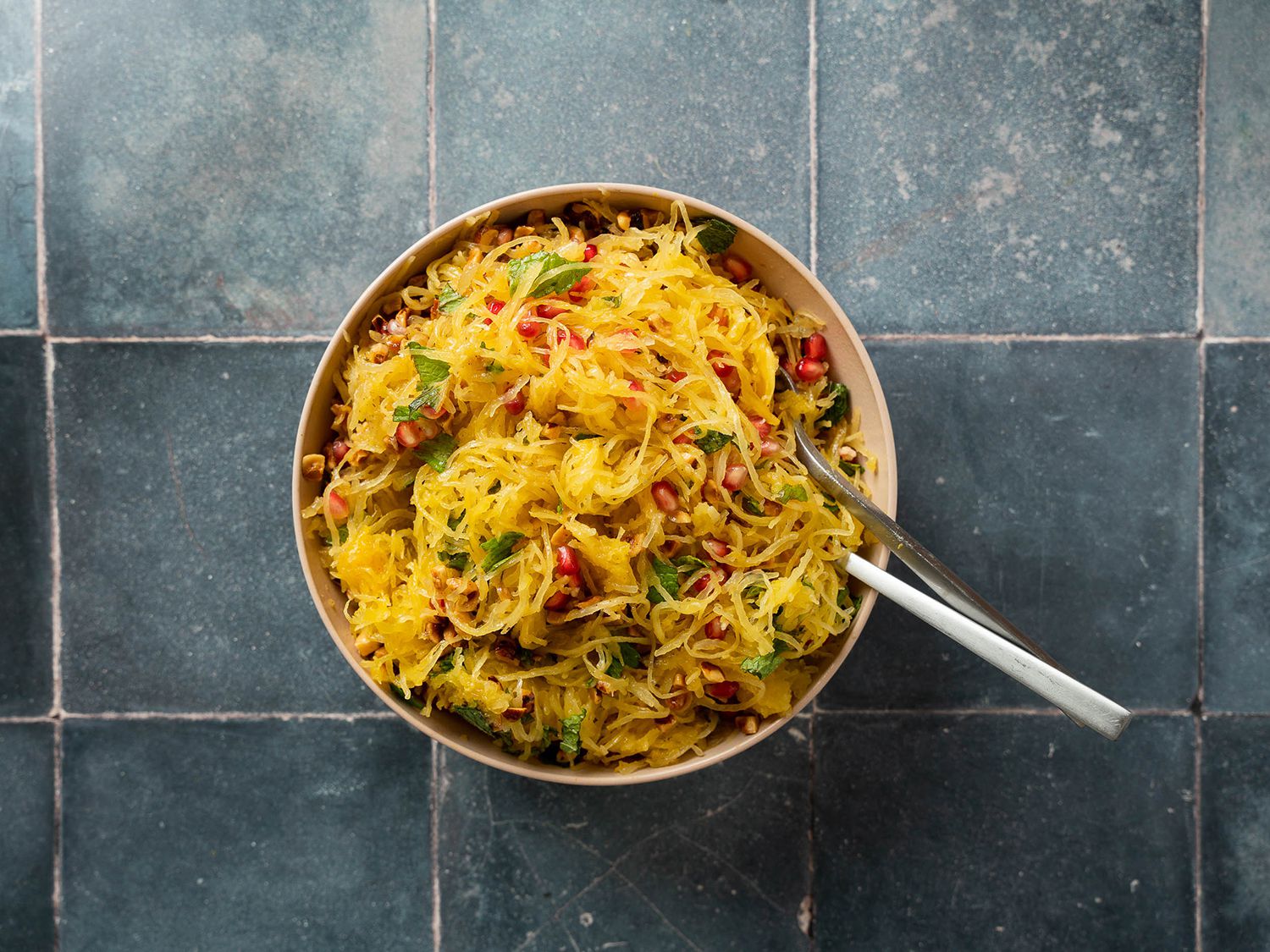 Bowl of spaghetti squash strands with hazelnuts, pomegranate, and mint mixed in