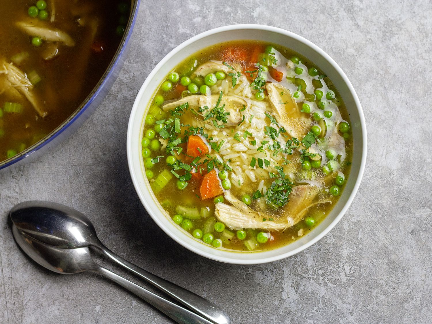 Chicken and rice soup poured into a white bowl.