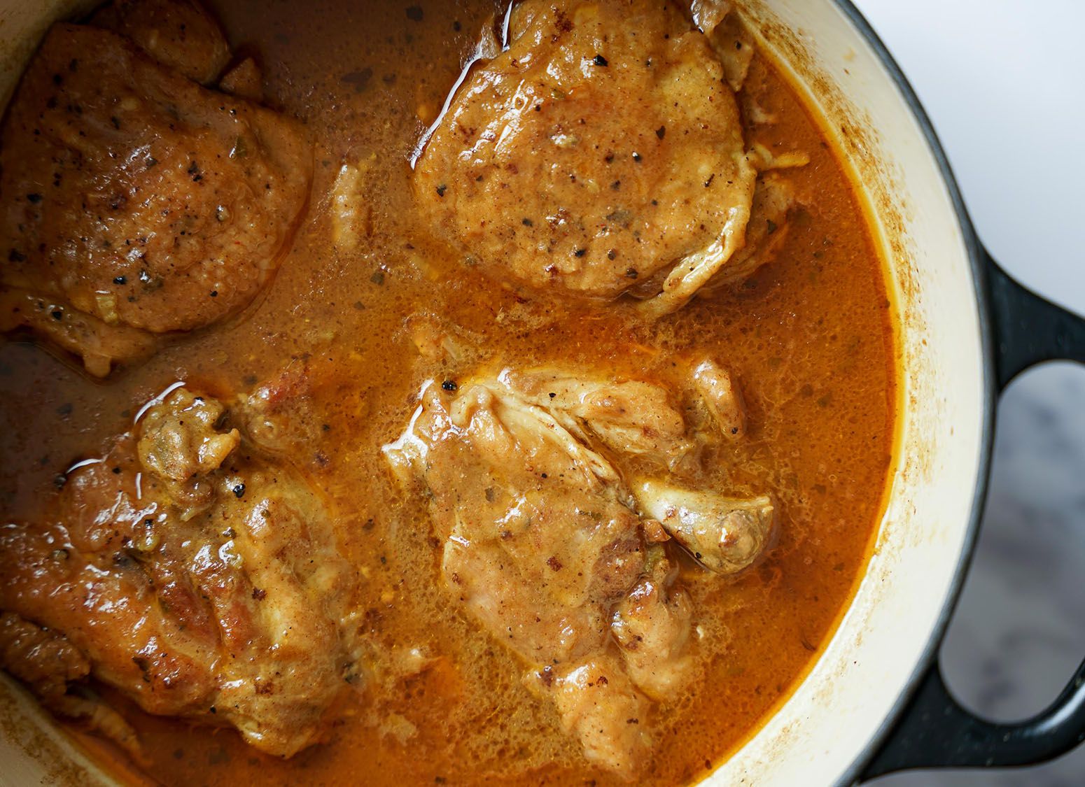 Chicken thighs in a brown sauce.