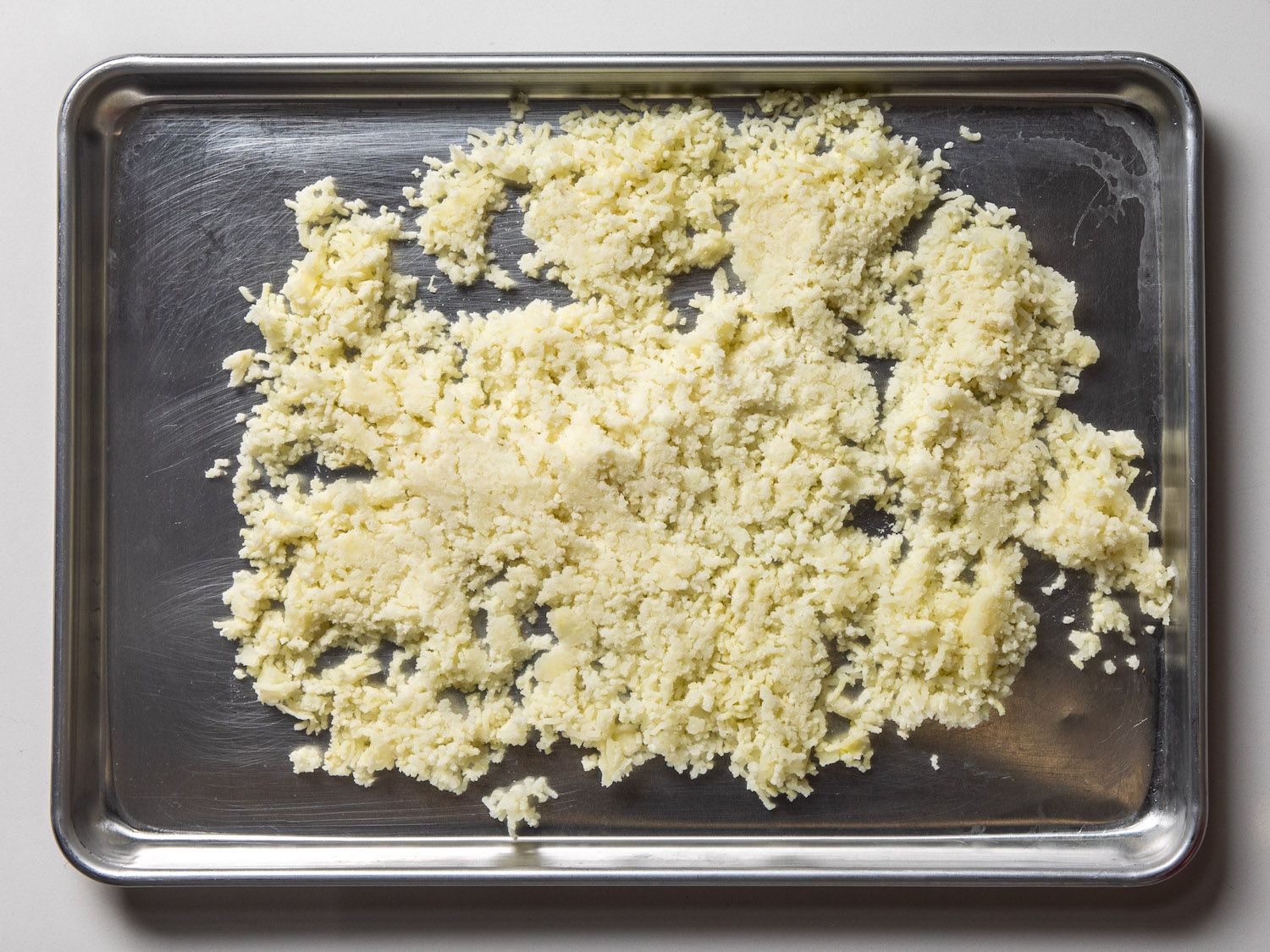 riced potatoes on rimmed baking sheet