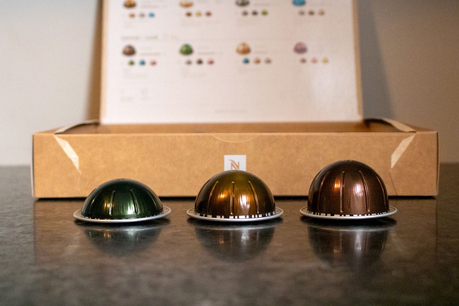 Three different sized Nespresso pods on a countertop