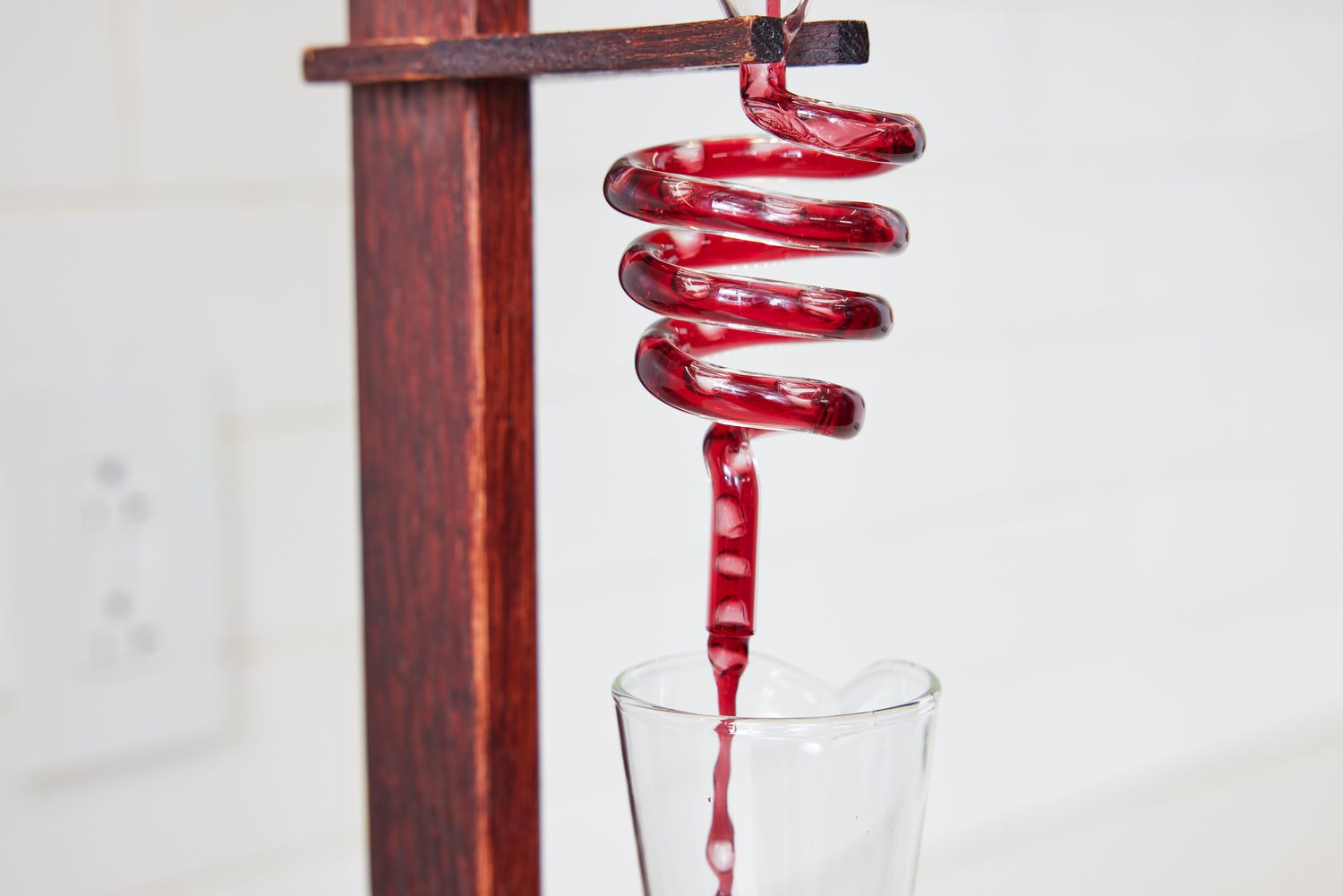 A closeup of wine traveling from the wine decanter tower into the carafe below
