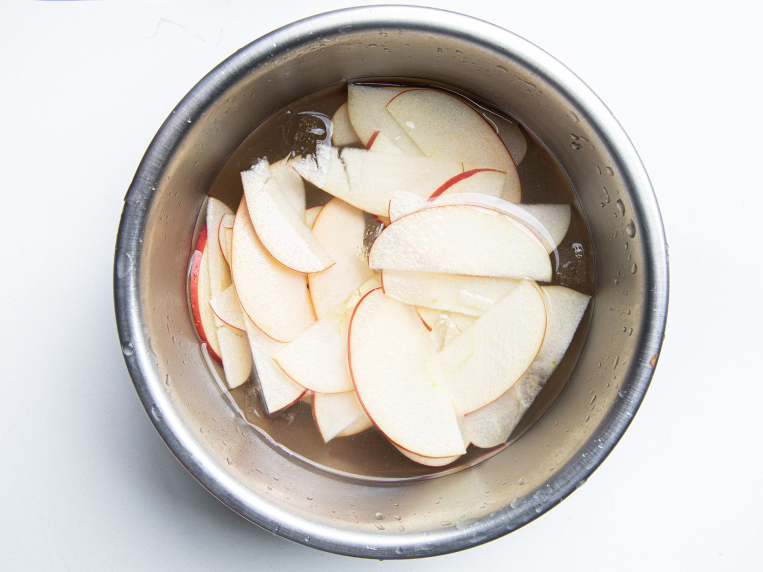 Cut apples in a metal bowl with water