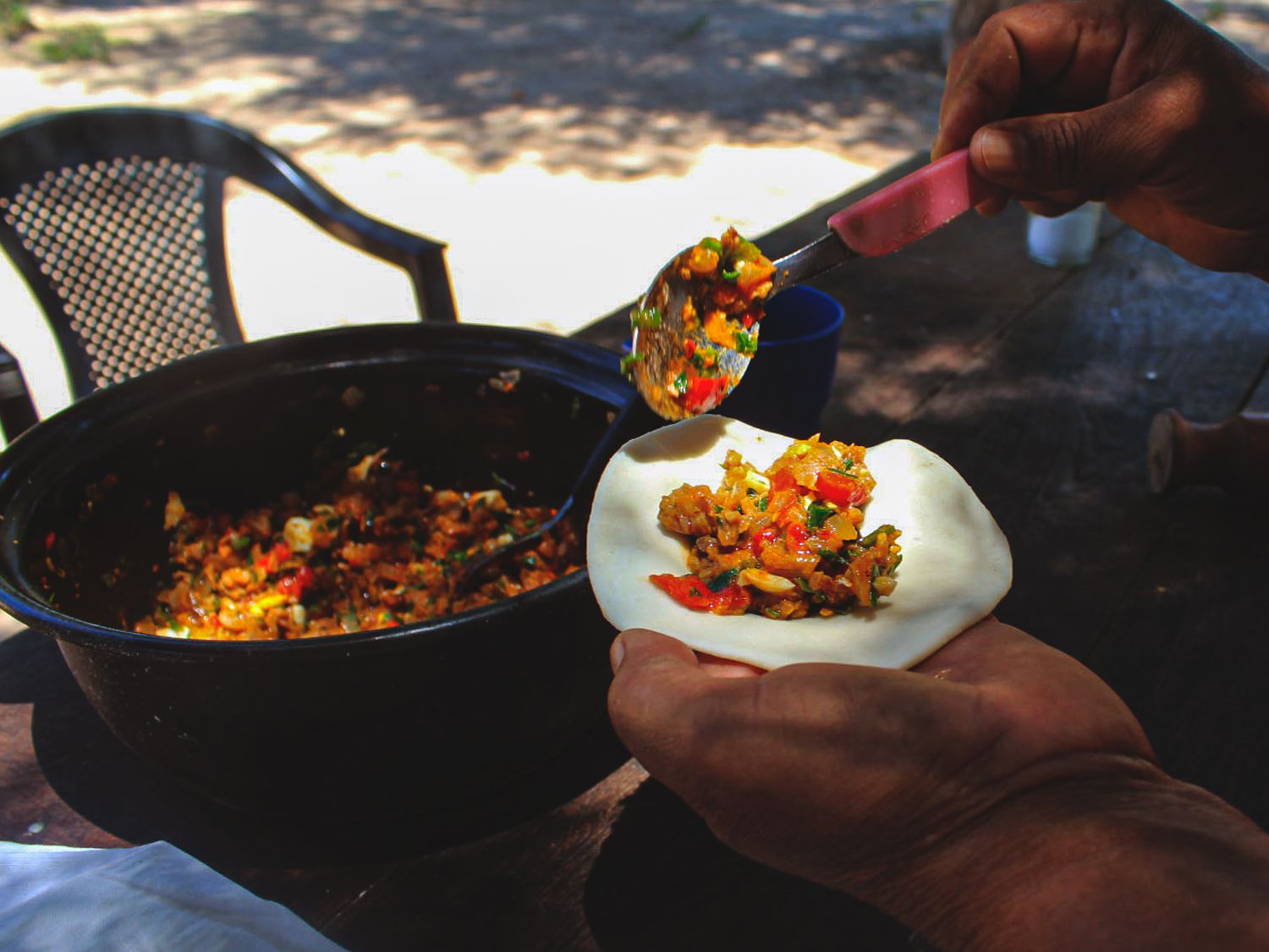 Graciela Cavana fills homemade empanada shells with pan-fried goat