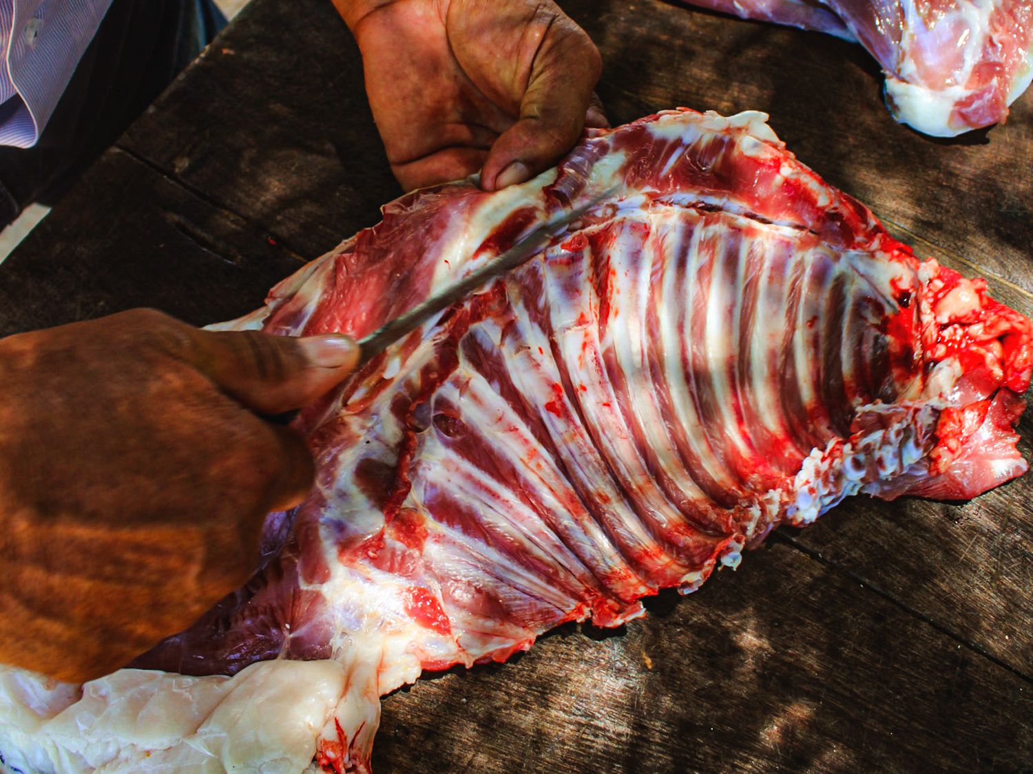 Jorge Luna carves goat to cook on the parrilla