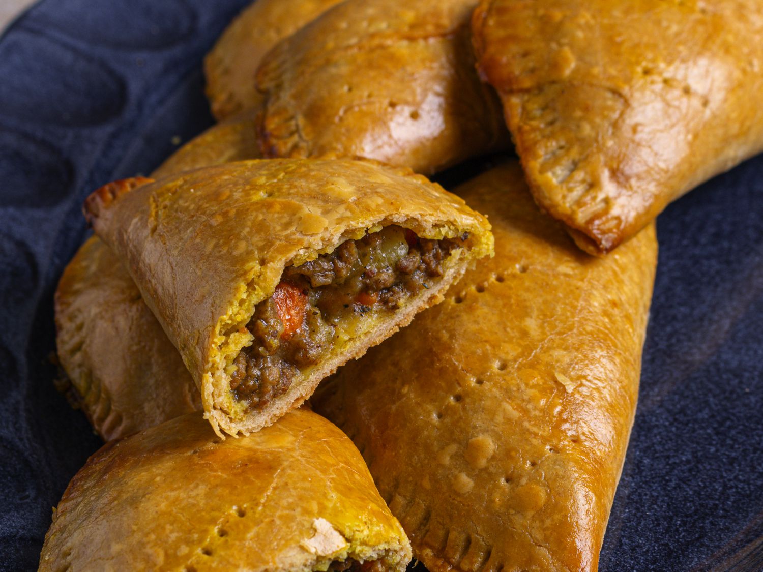 Meat pie sliced in half showing a beef and vegetable filling.