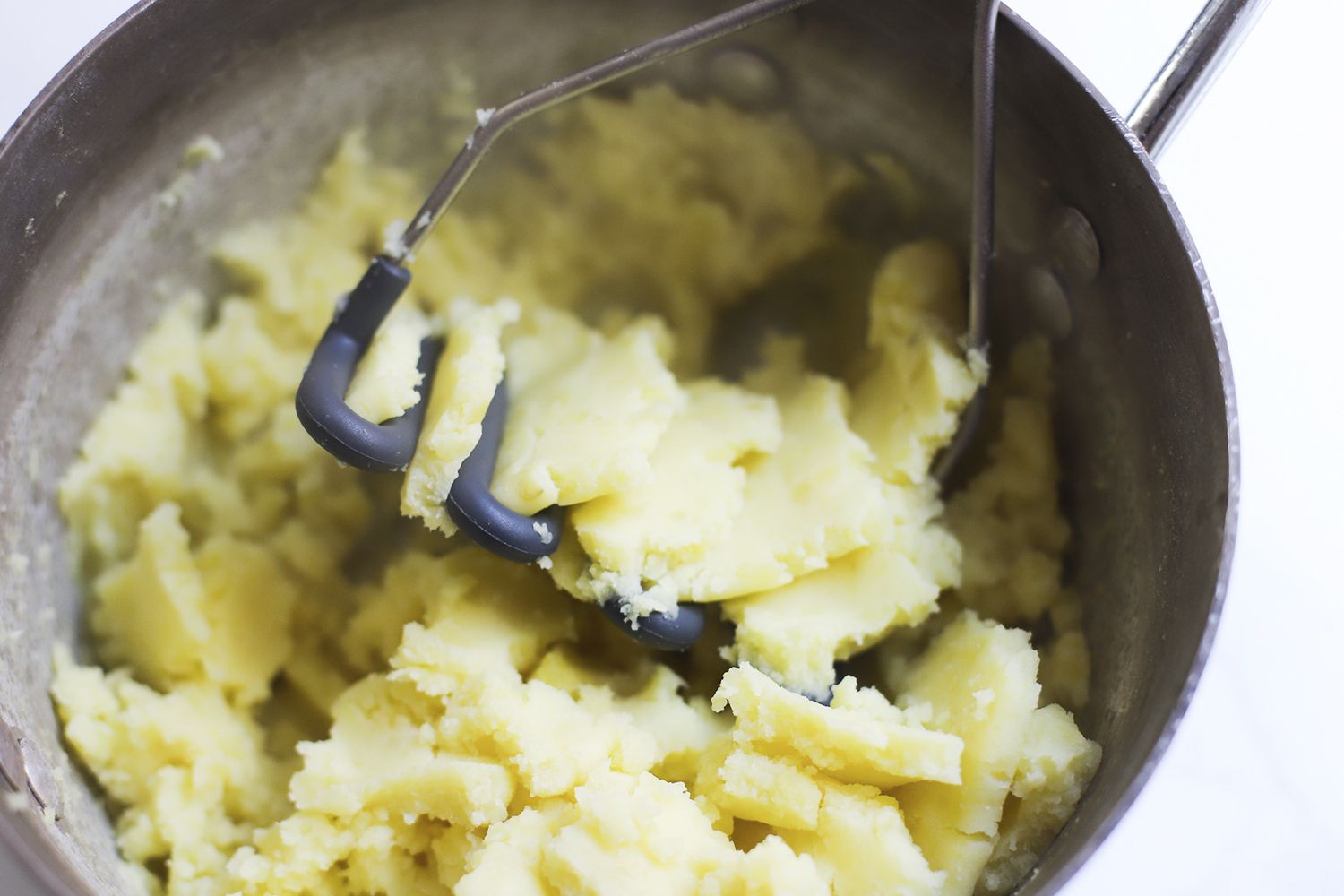 A closeup of the Tovolo's silicone head mashing potatoes
