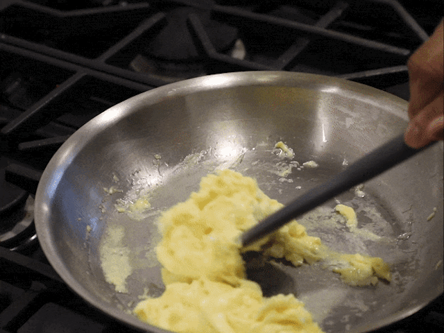 A GIF of scrambling eggs in a small stainless steel skillet