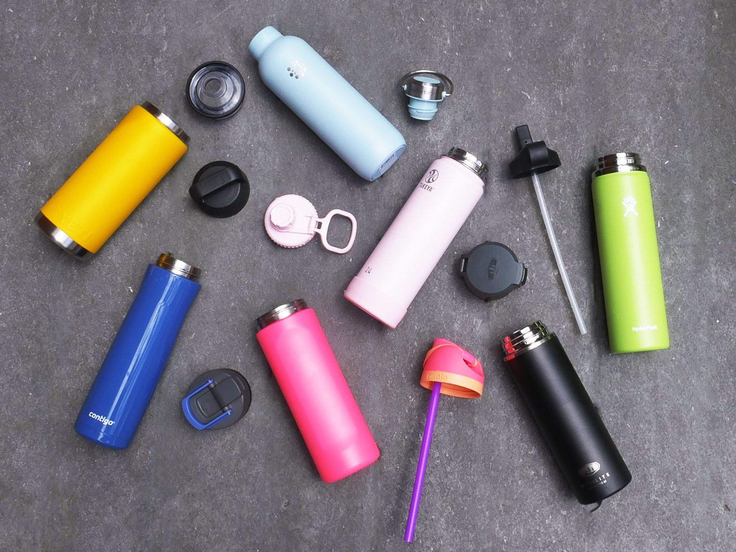a variety of stainless steel water bottles on a grey surface
