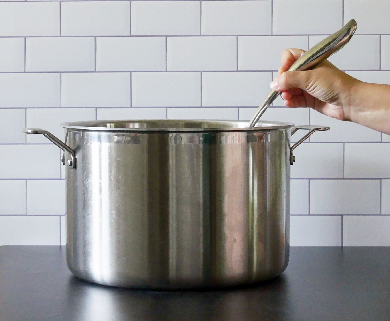 cuisinart ladle being held in a pot to show the curve of the handle