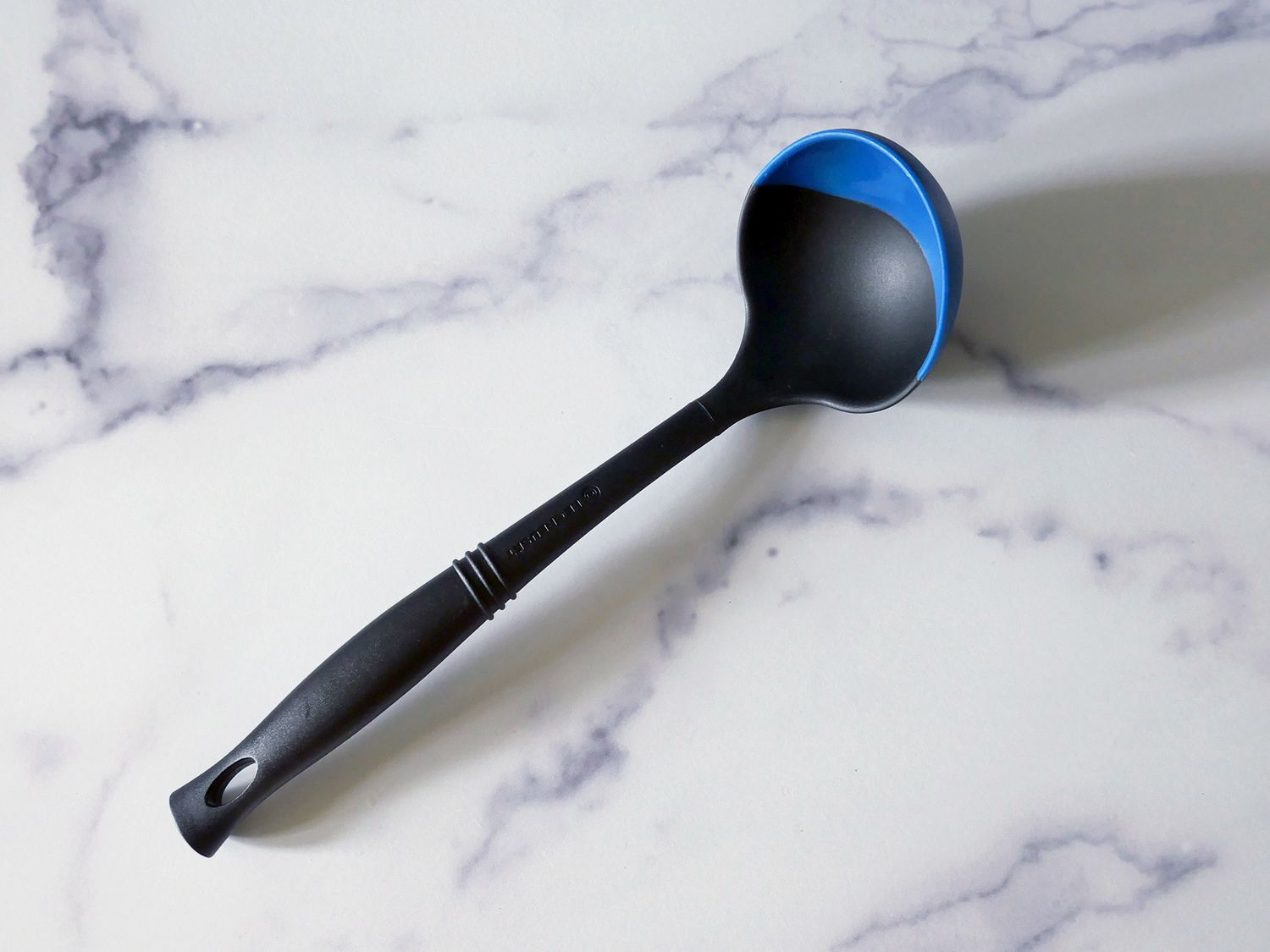 the le creuset ladle on a marble countertop