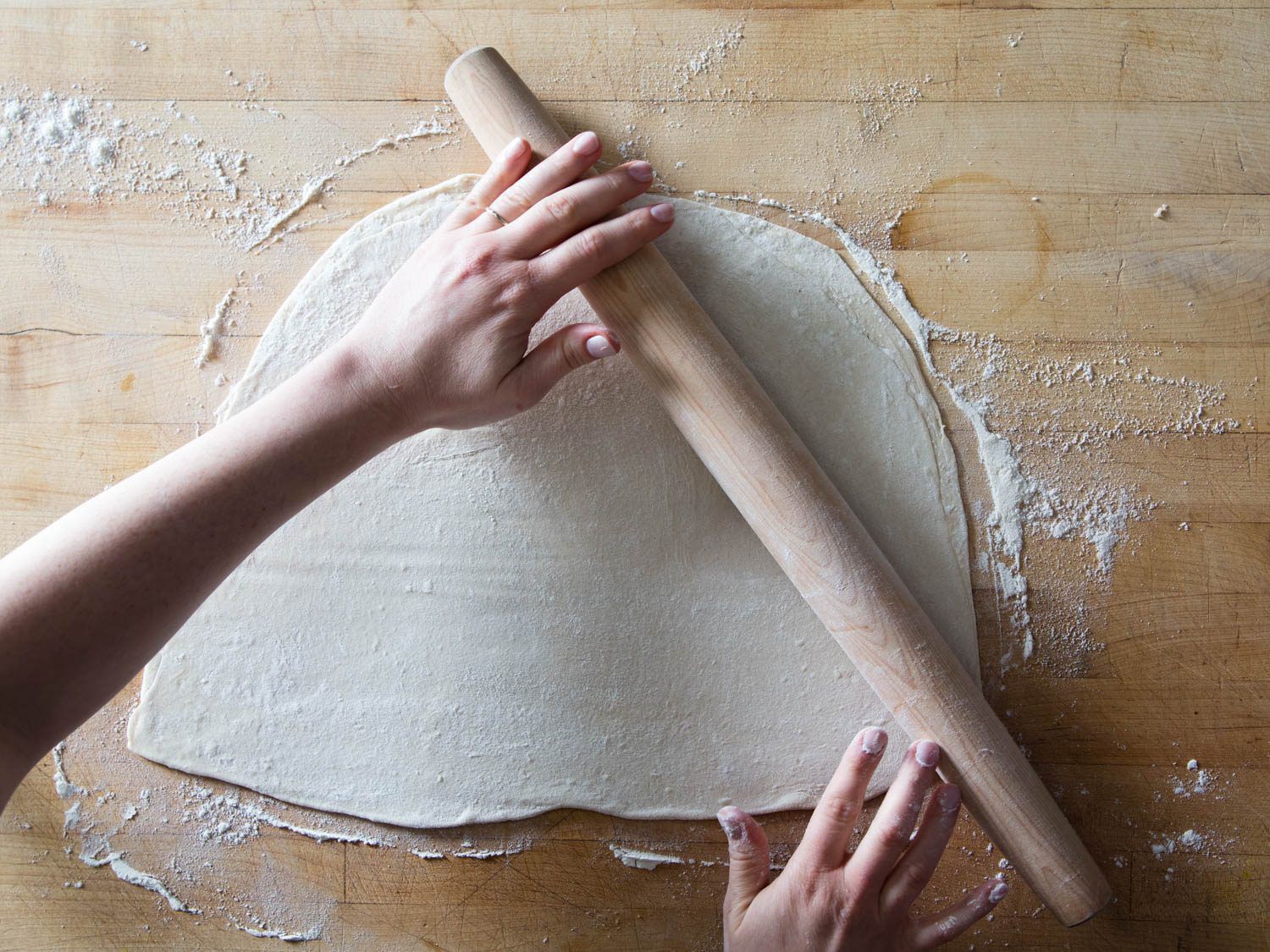 dough being rolled with a rolling pin