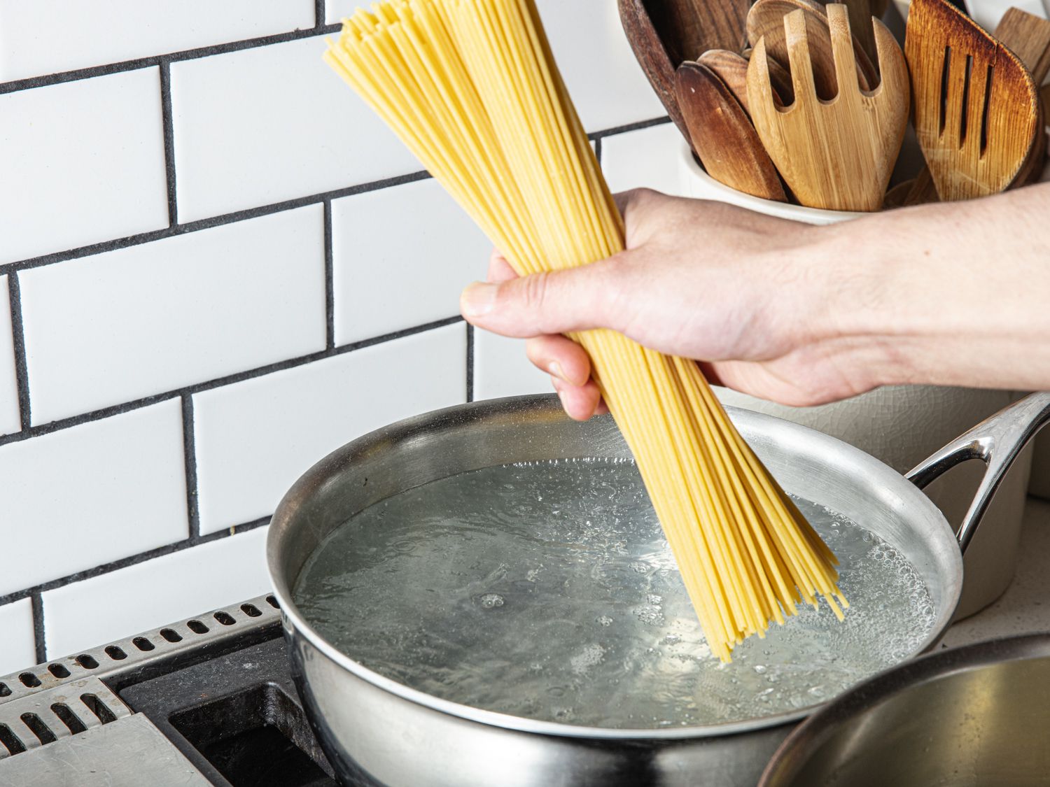 Spaghetti being dropped into boiling water