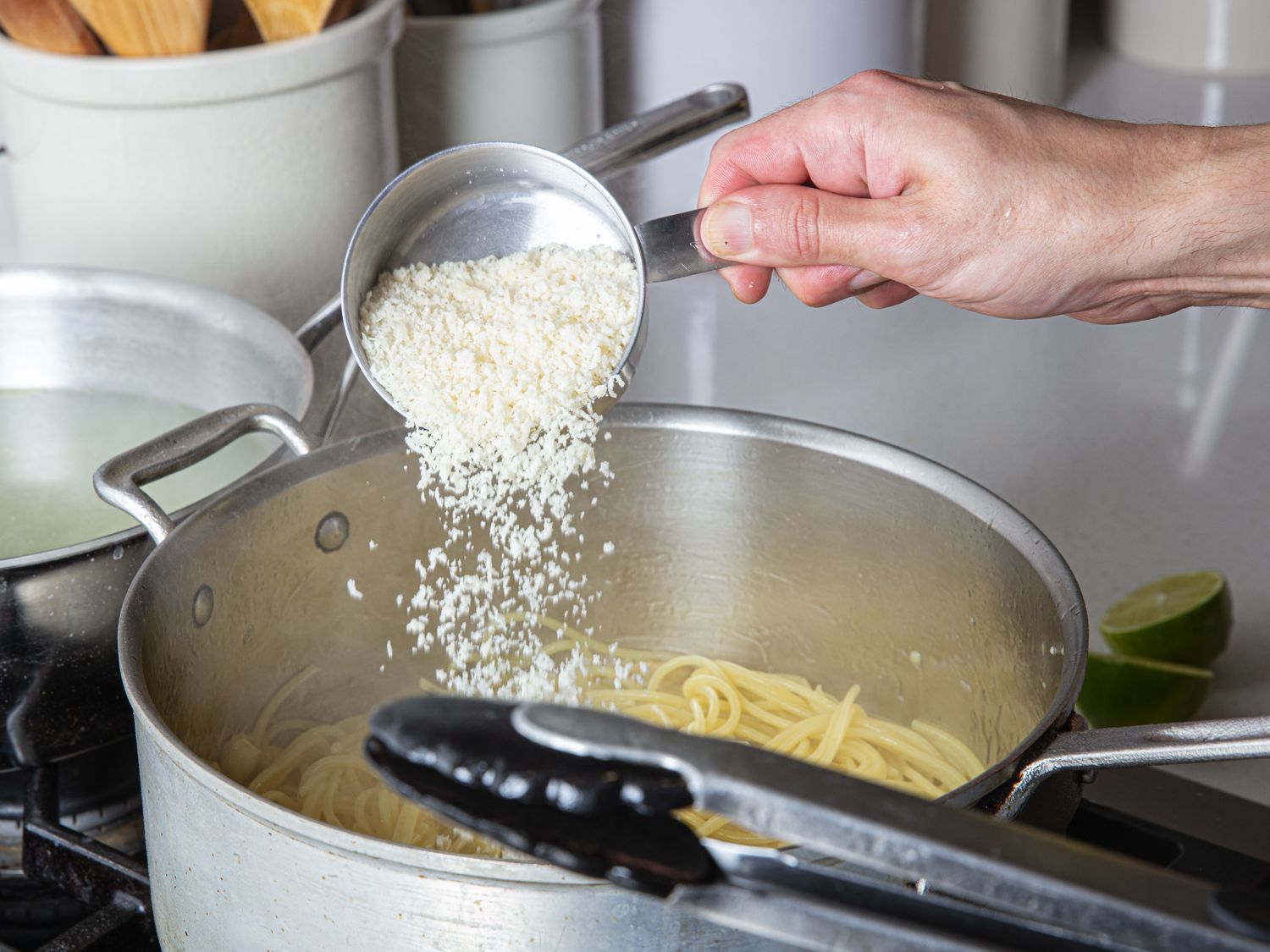 Cheese being added to pasta pan