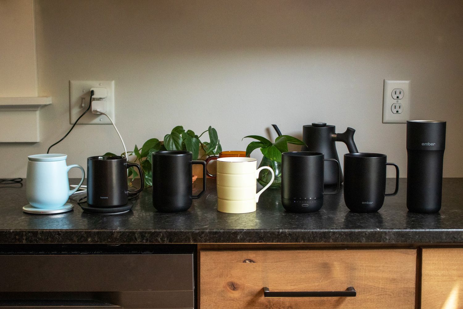 seven temperature control mugs on a countertop