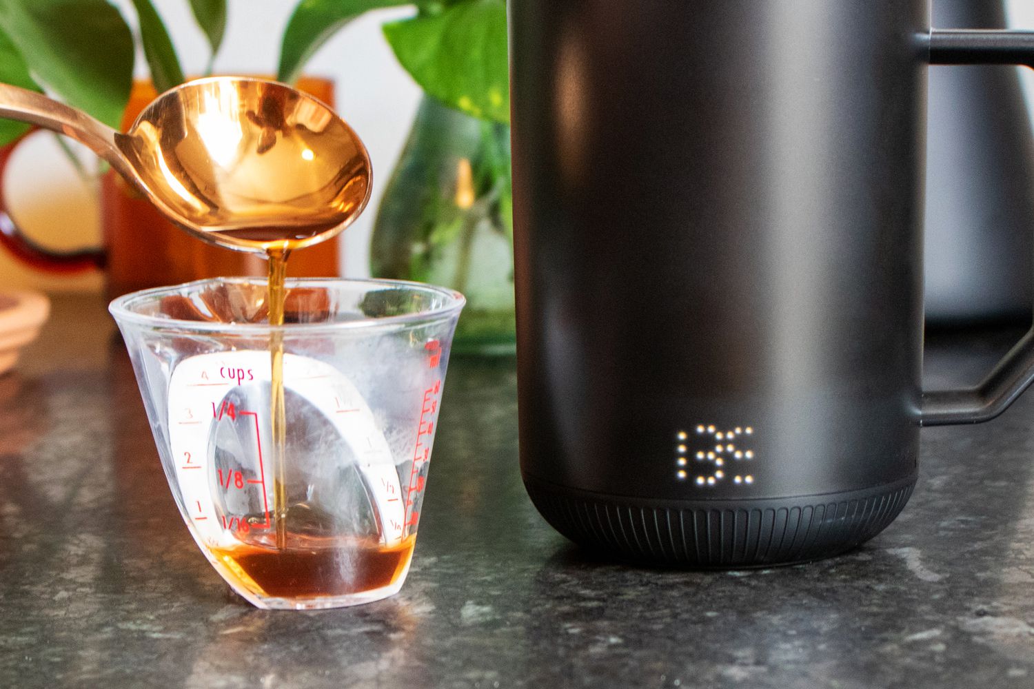 The iOn Mug with a small container beside it and a cupping spoon with coffee in it