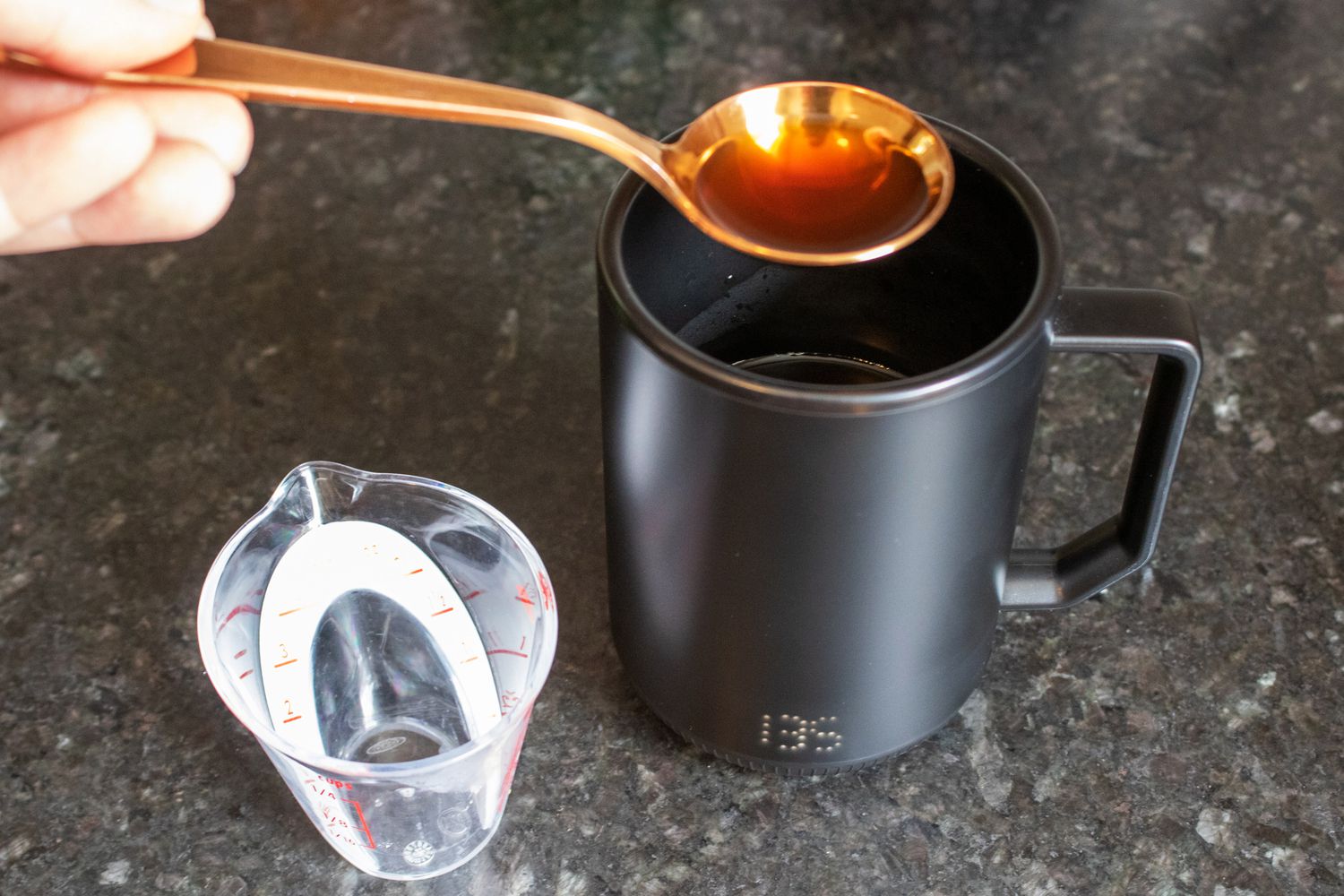 a cupping spoon retrieving coffee from a 135F mug