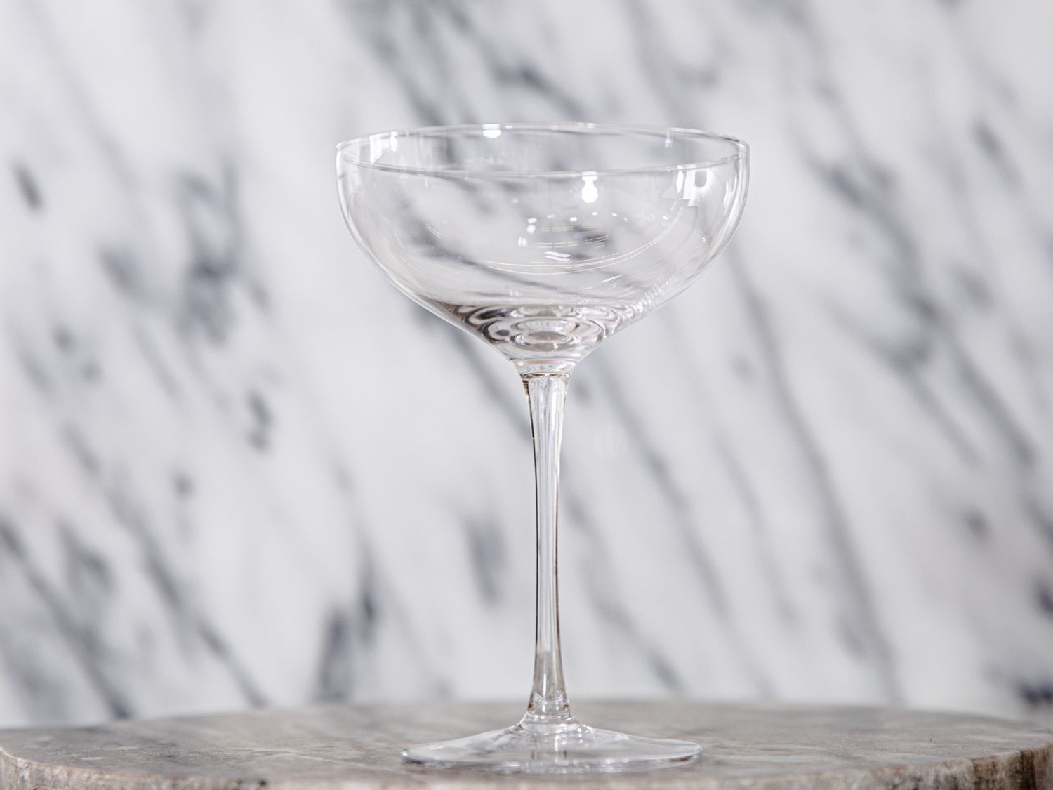 The bacador coupe glass against a grey and white background