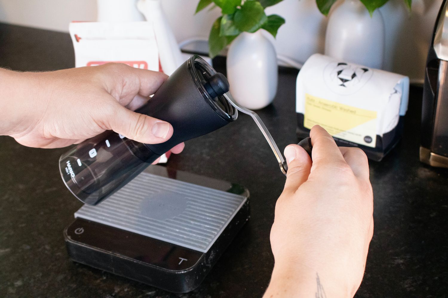 a hand is cranking a handheld grinder