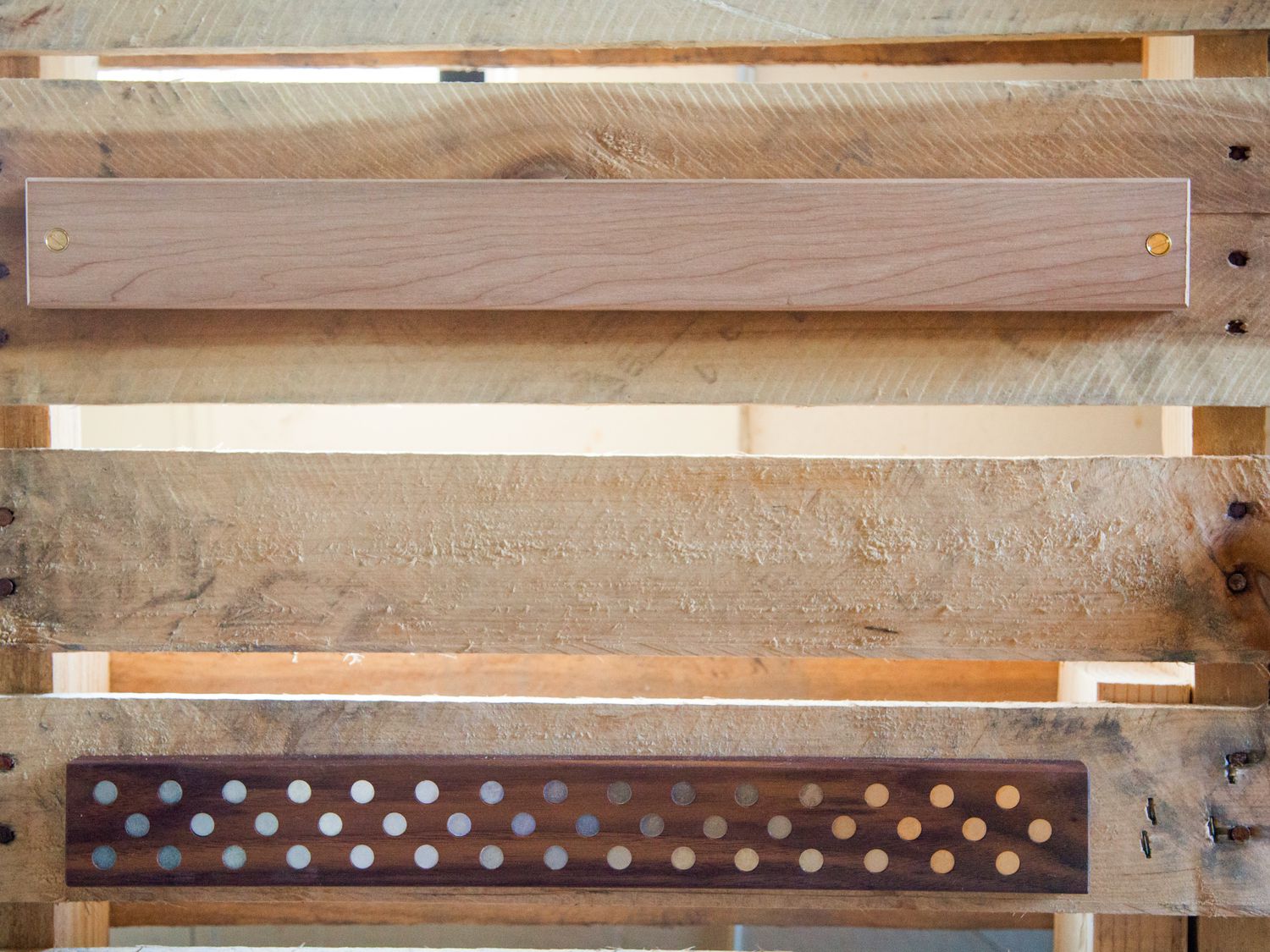 two wooden magnetic knife holders screwed onto a wooden pallet