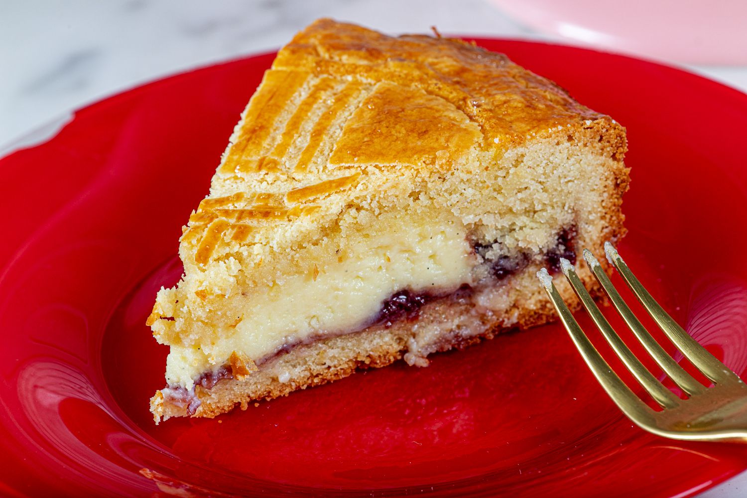 A slice of gateau basque on a red plate