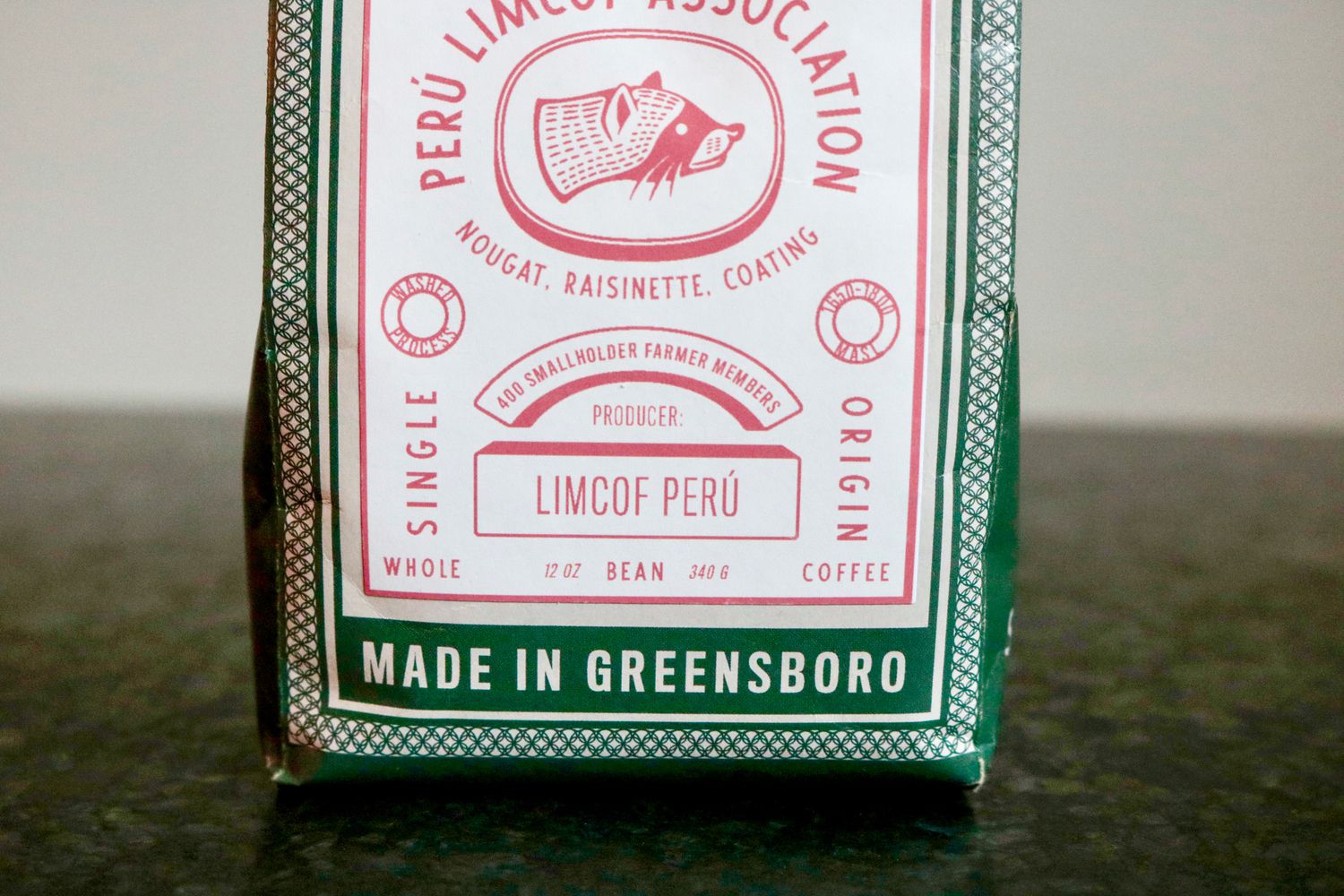 a green and white coffee bag sitting on a black countertop