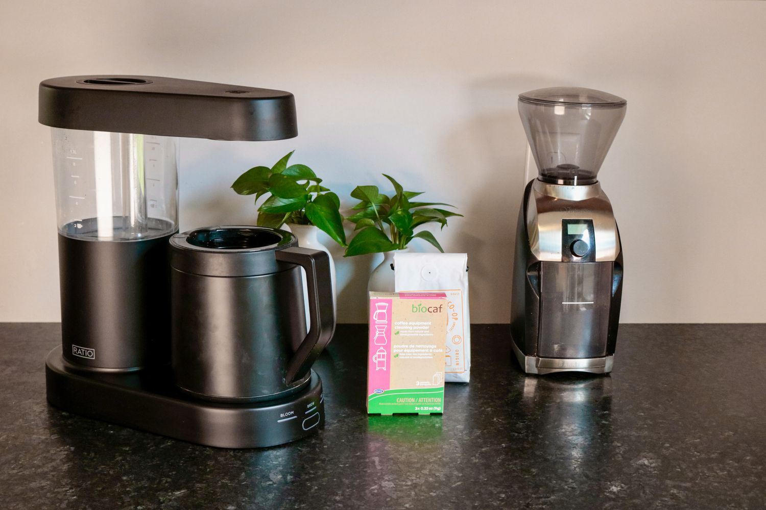 A Ratio six coffee maker sitting on a countertop with a burr grinder beside it