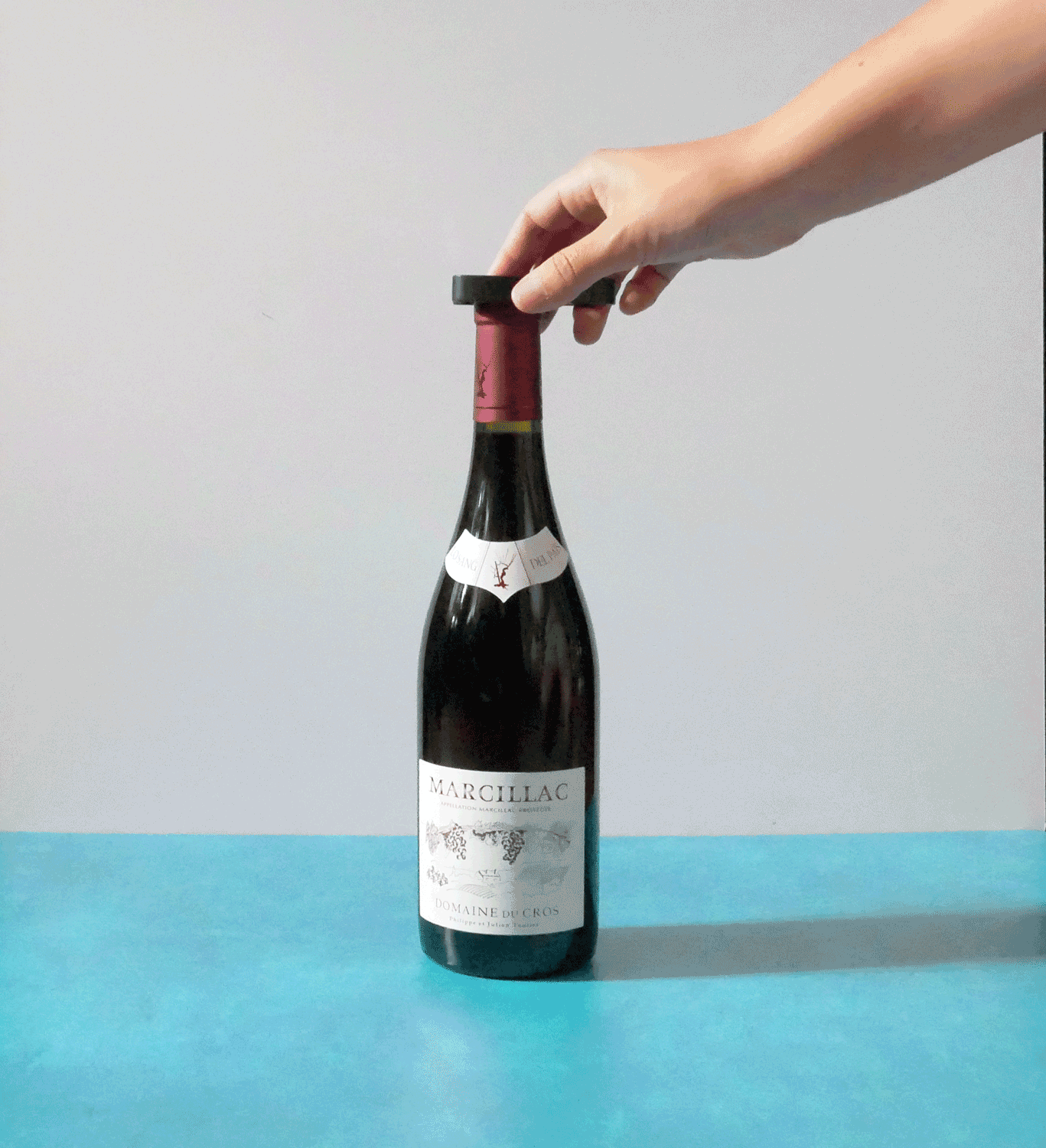 using a foil cutter to cut the metal cap off the wine.