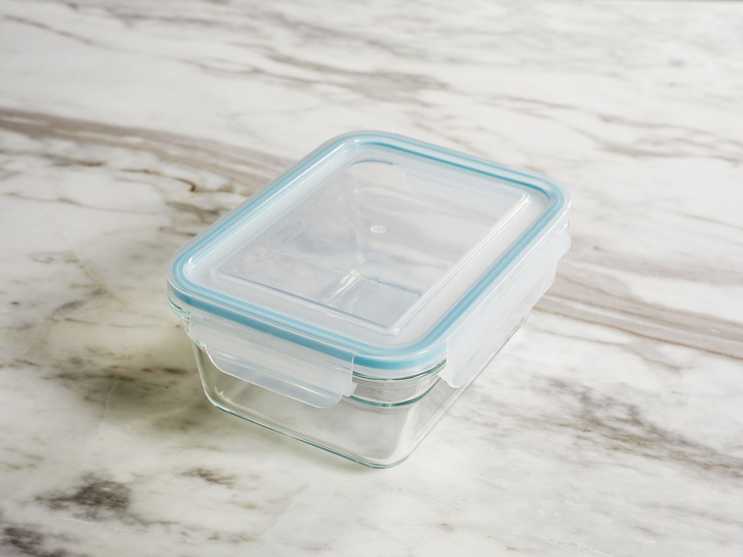 A glass storage container on a marble surface